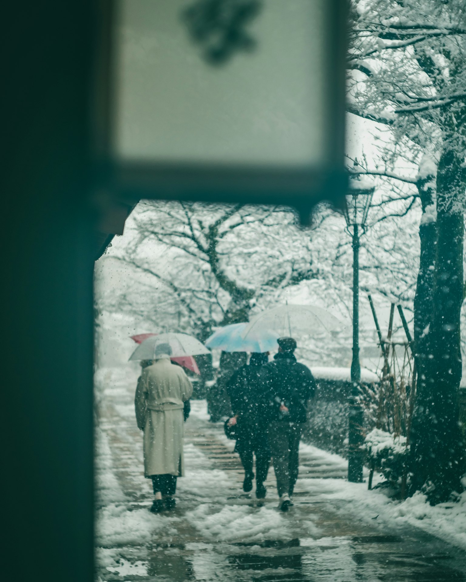 Personas caminando en la nieve con paraguas
