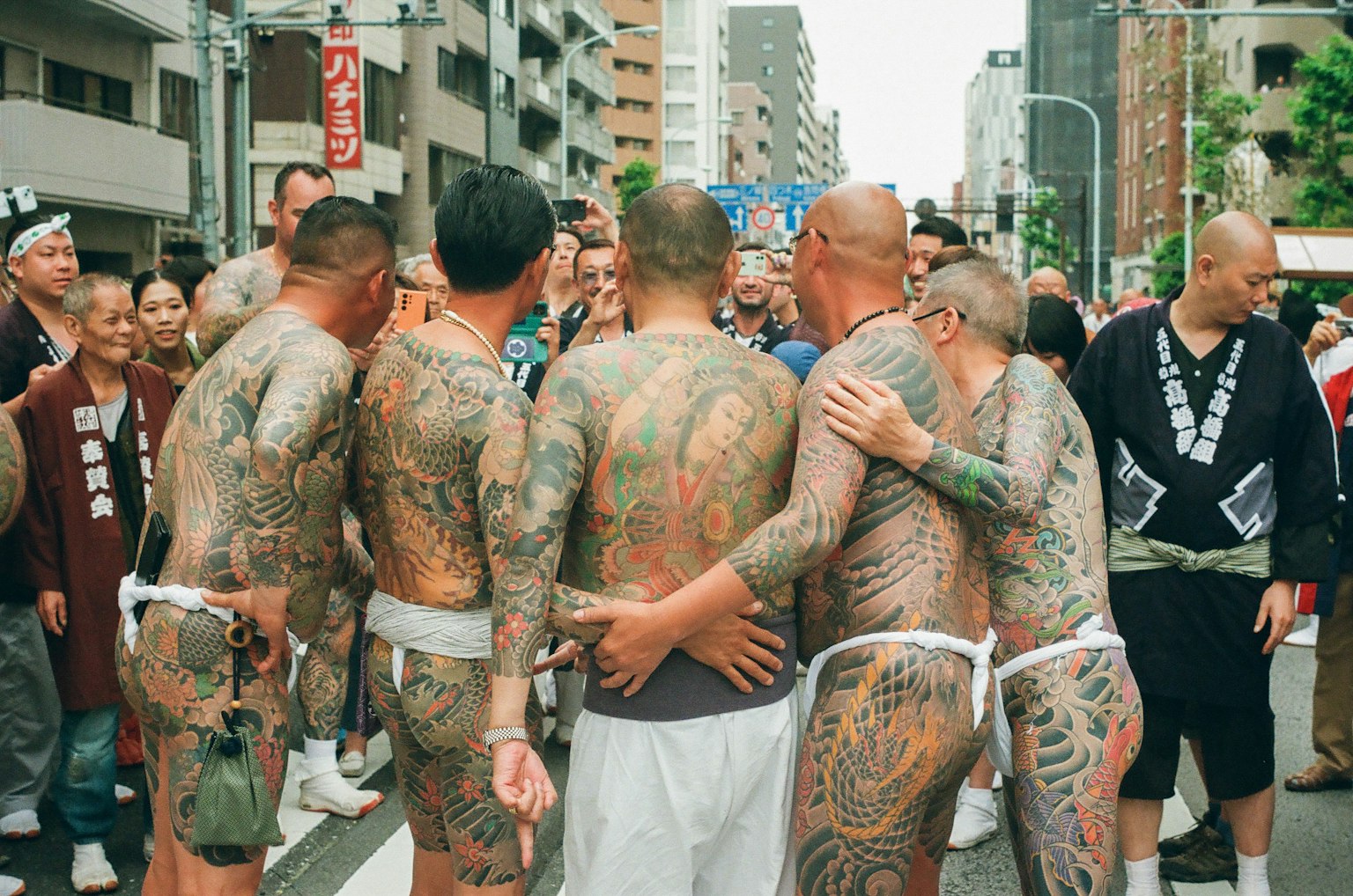 Hommes avec des tatouages dans le dos rassemblés lors d'un festival