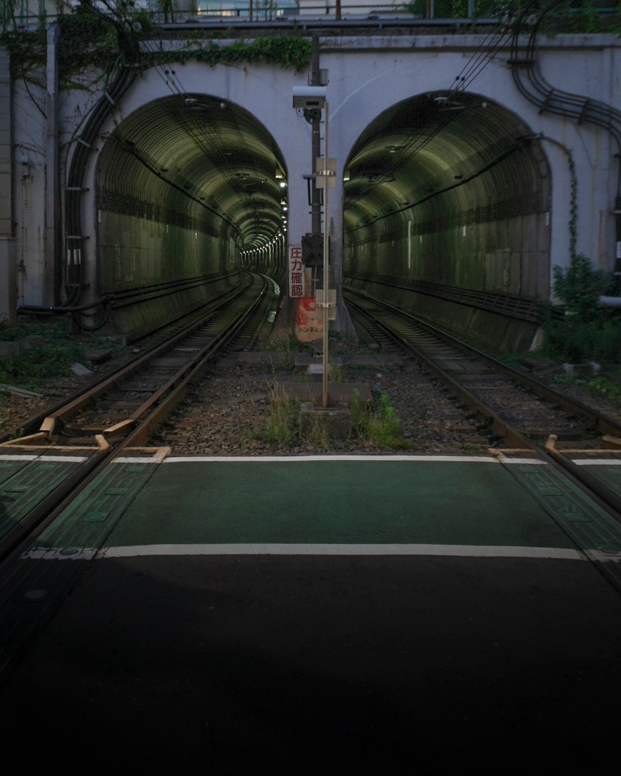 線路がトンネルへ続く駅のホーム風景