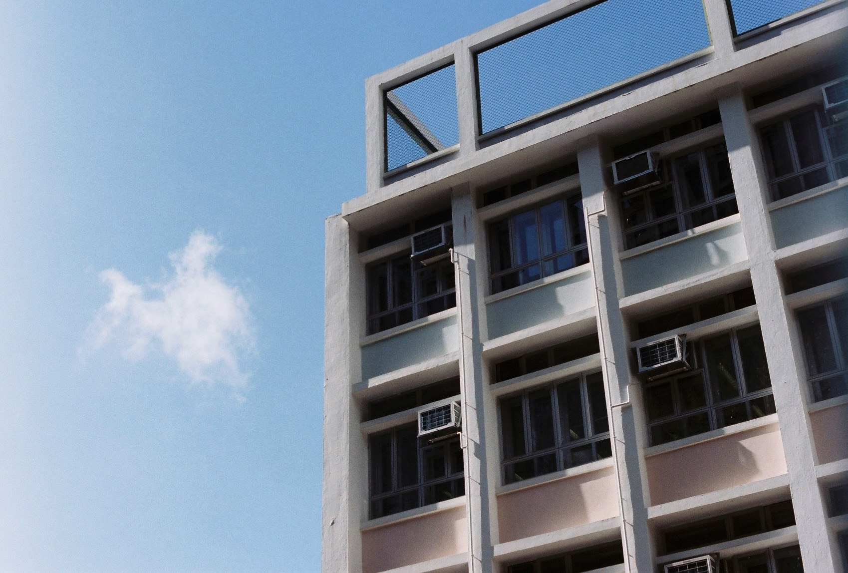 青空の下で光と影が映える学校の建物の窓と屋根