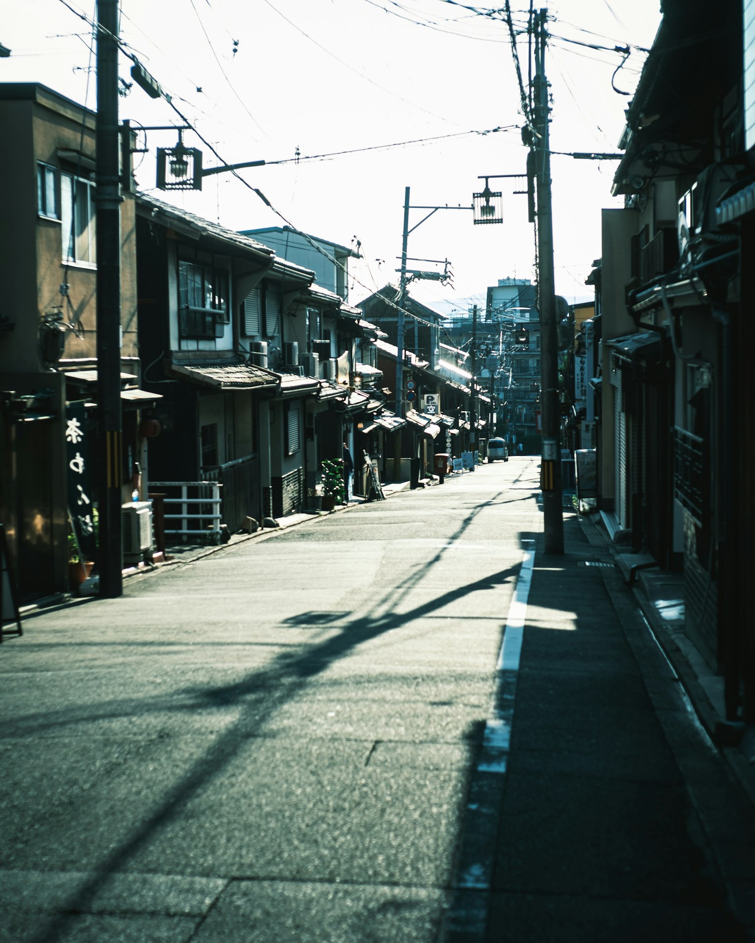 静かな街並みの古い日本の通り、木造の家々が並ぶ、日差しが差し込む