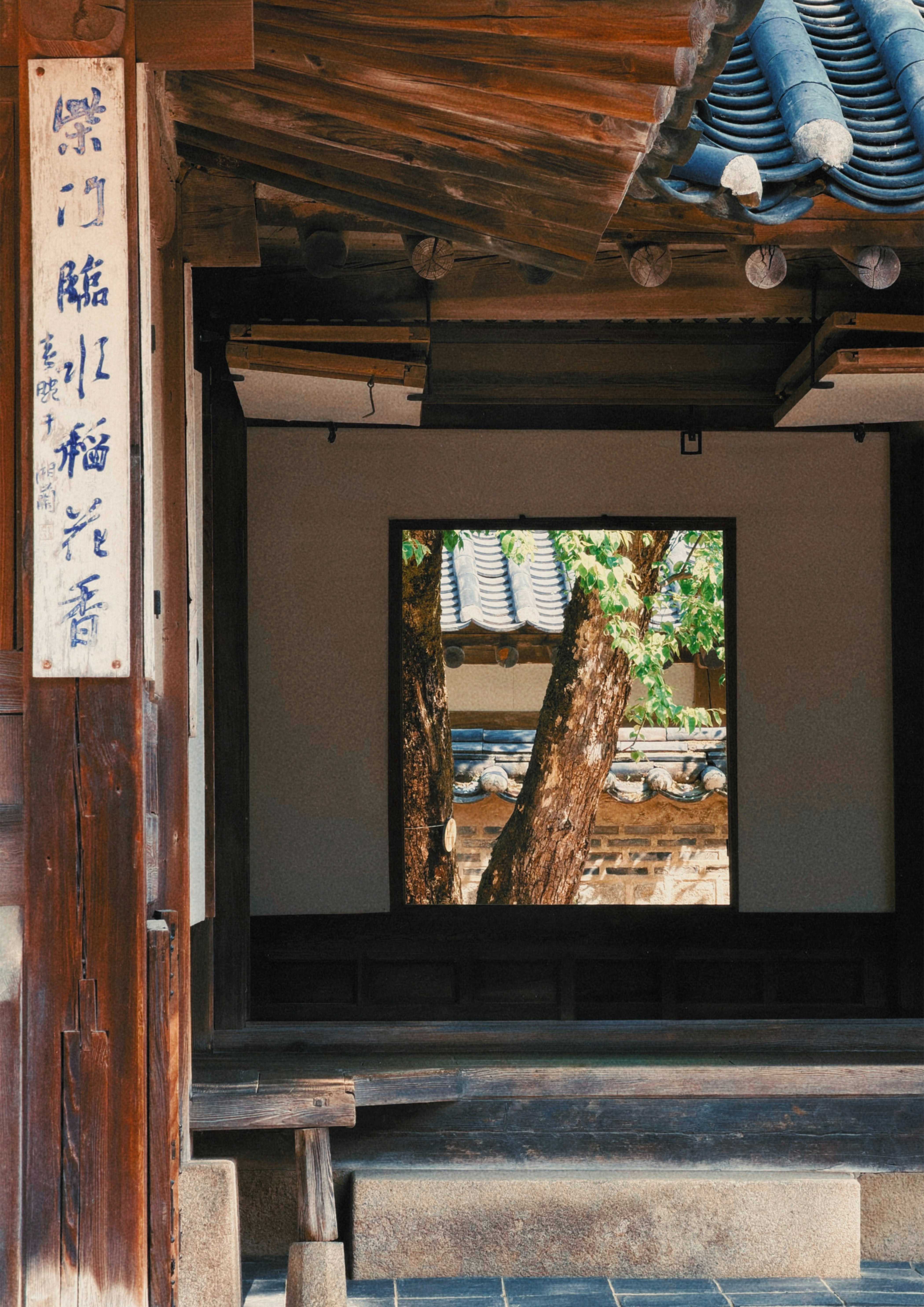 木の梁と格子のある古い建物の内側から見える中庭