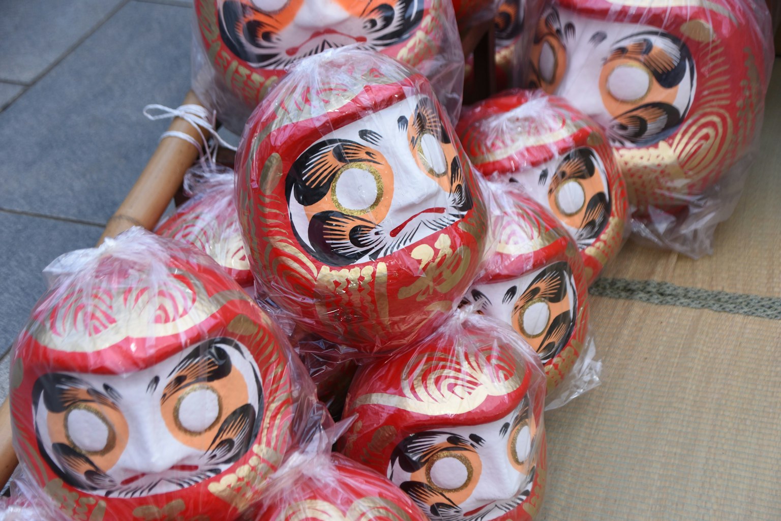 Una collezione di bambole Daruma rosse avvolte nella plastica