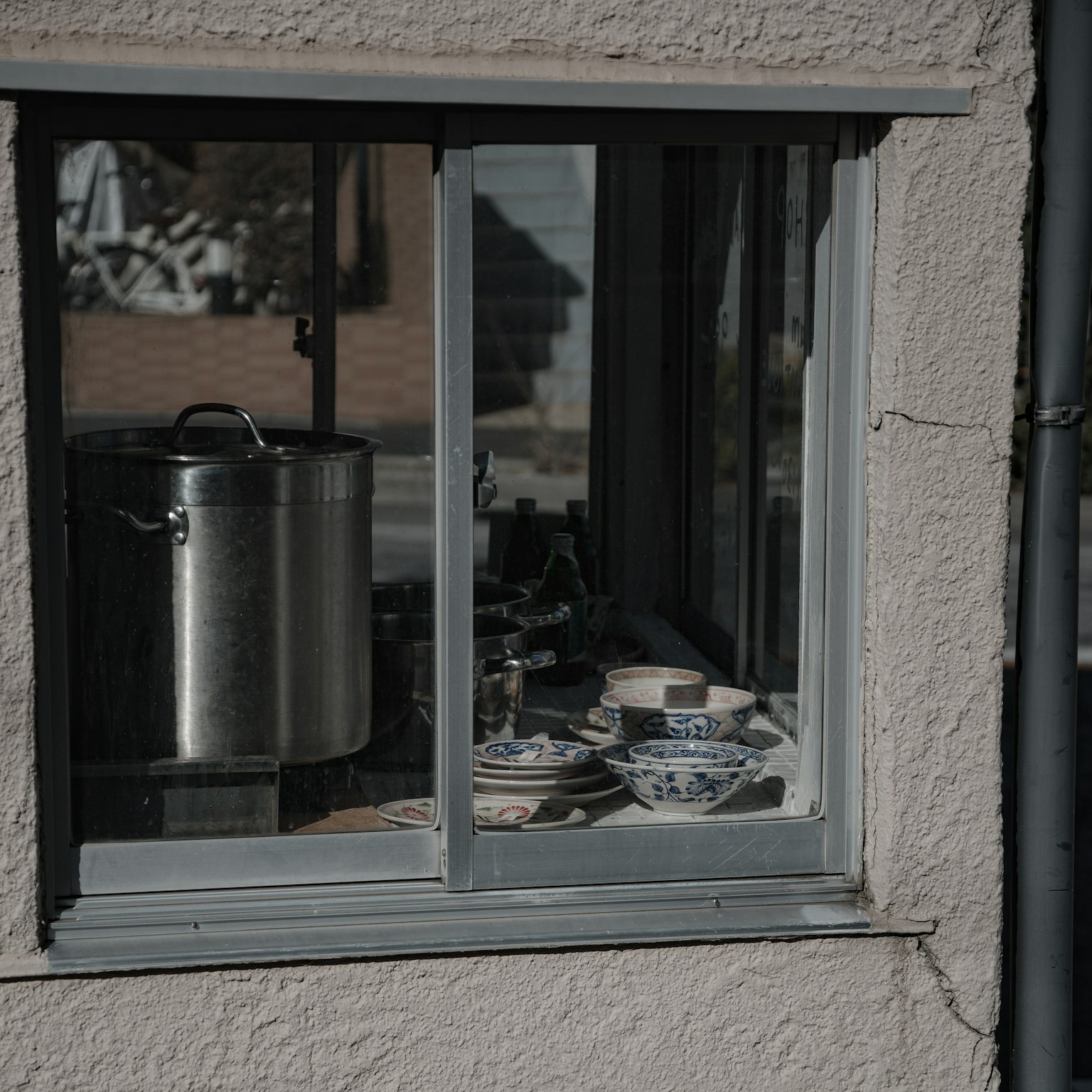 View of a kitchen through a window featuring pots and dishes