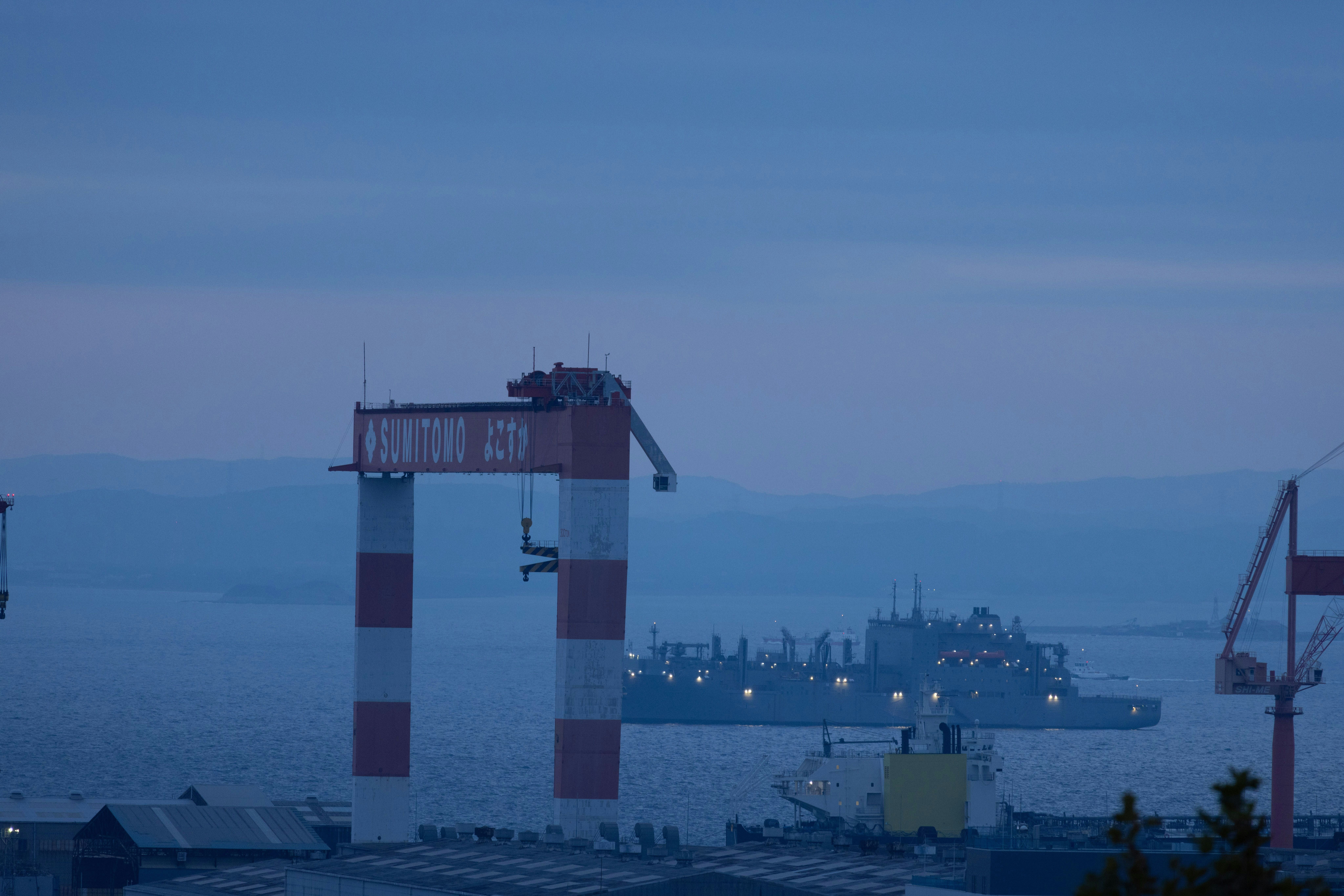 vue du quai du port avec un navire au large et des lumières nocturnes