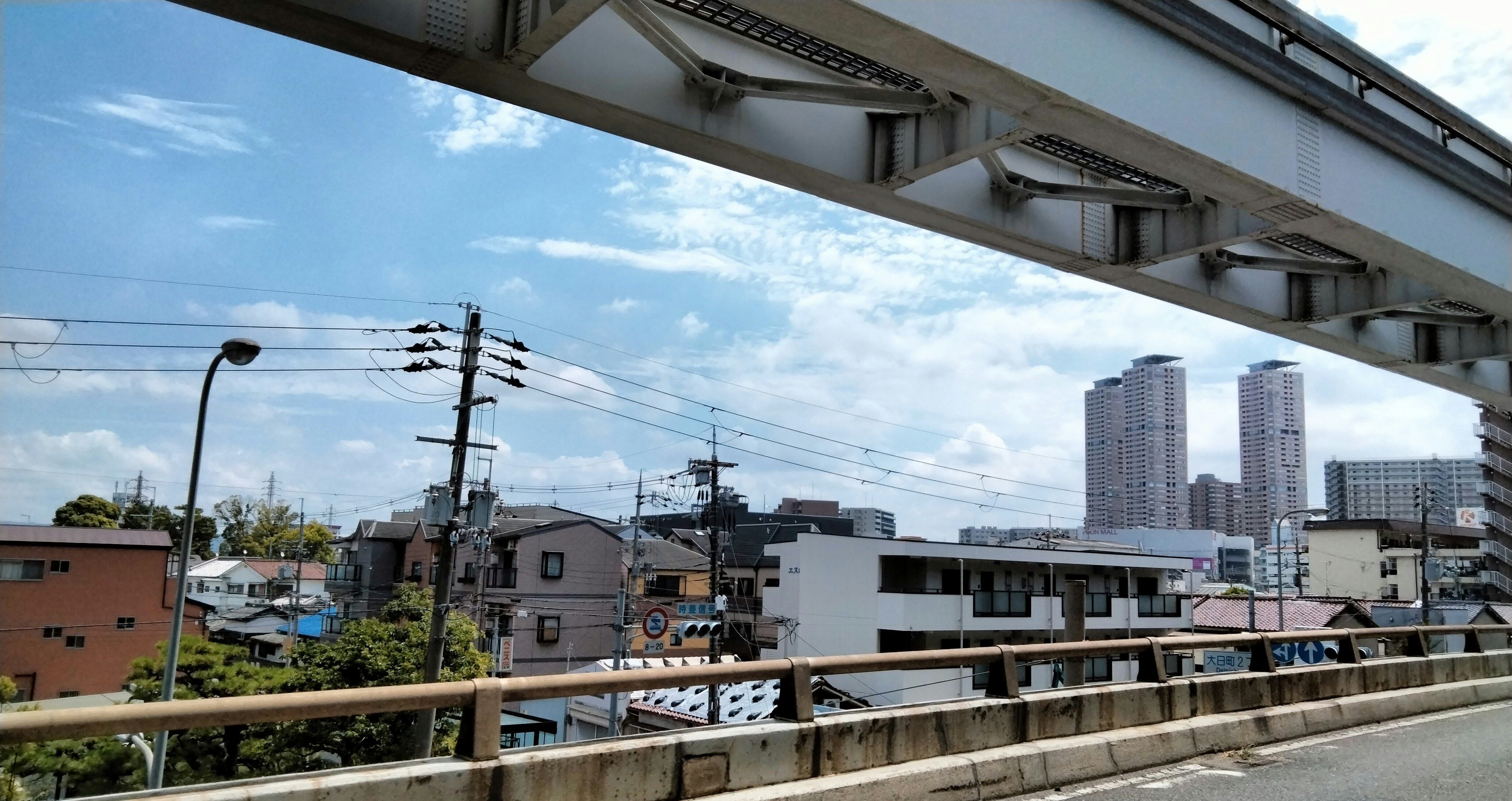 高架下から見える都市の街並みと高層マンション群