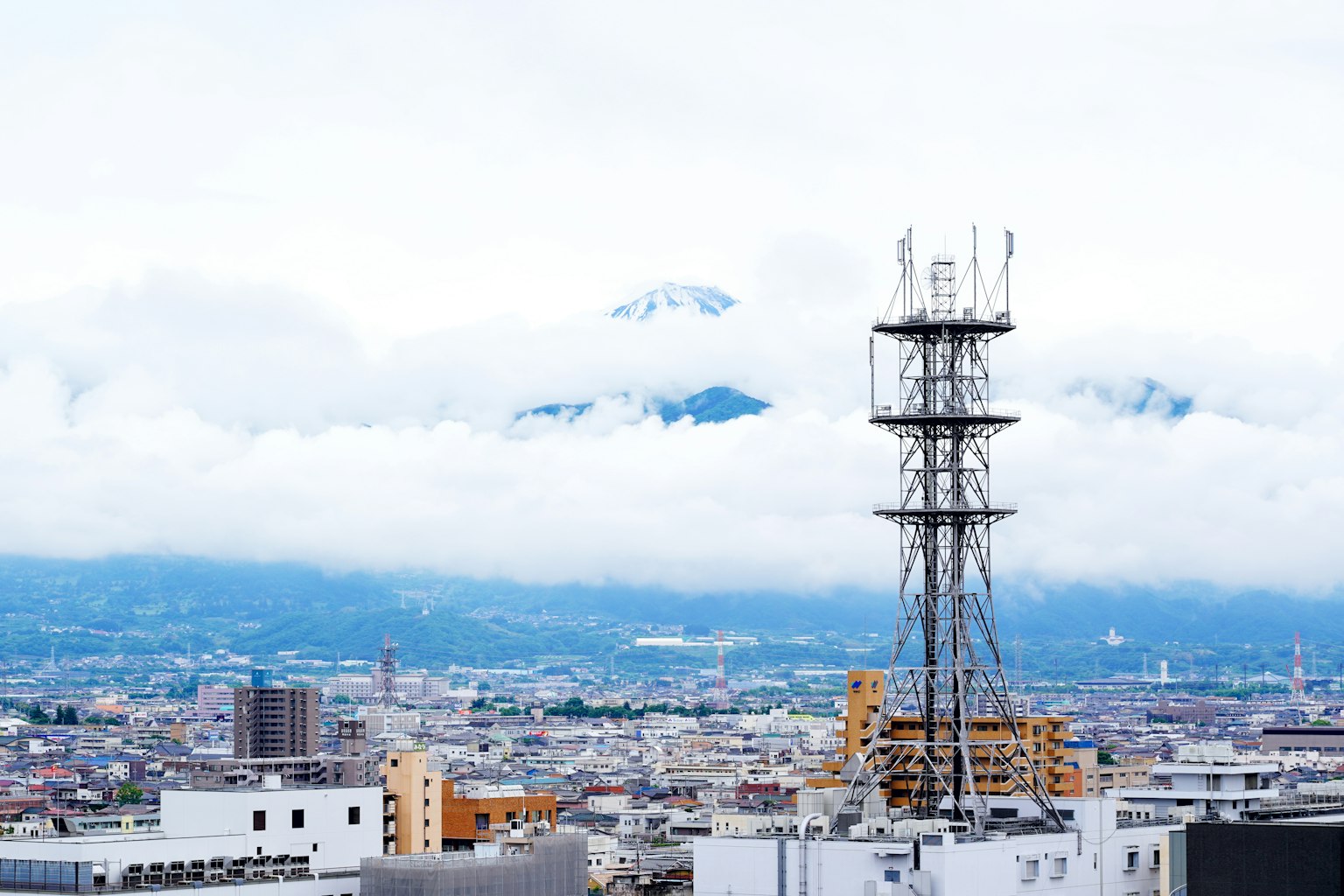 城市景观，背景有通信塔和山