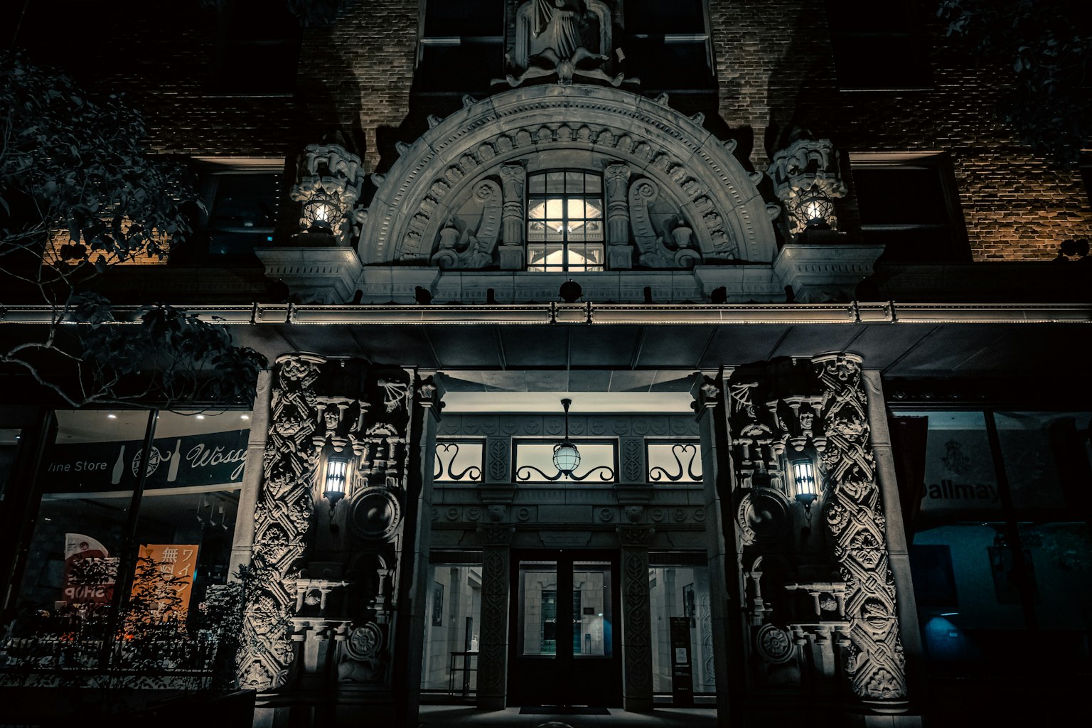 Entrée d'un bâtiment la nuit avec des sculptures et un éclairage complexes