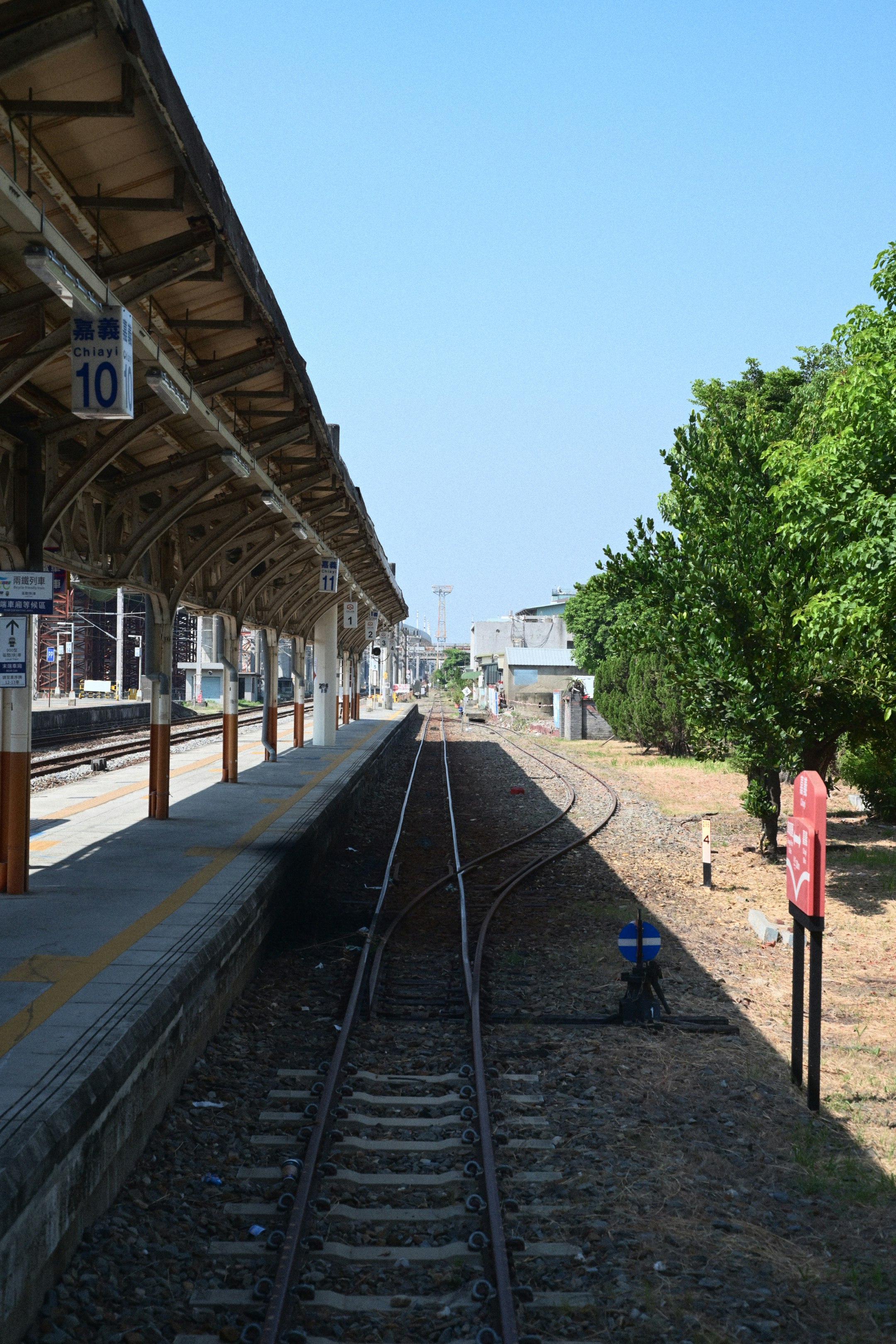 駅のホームに伸びる線路と木造の屋根