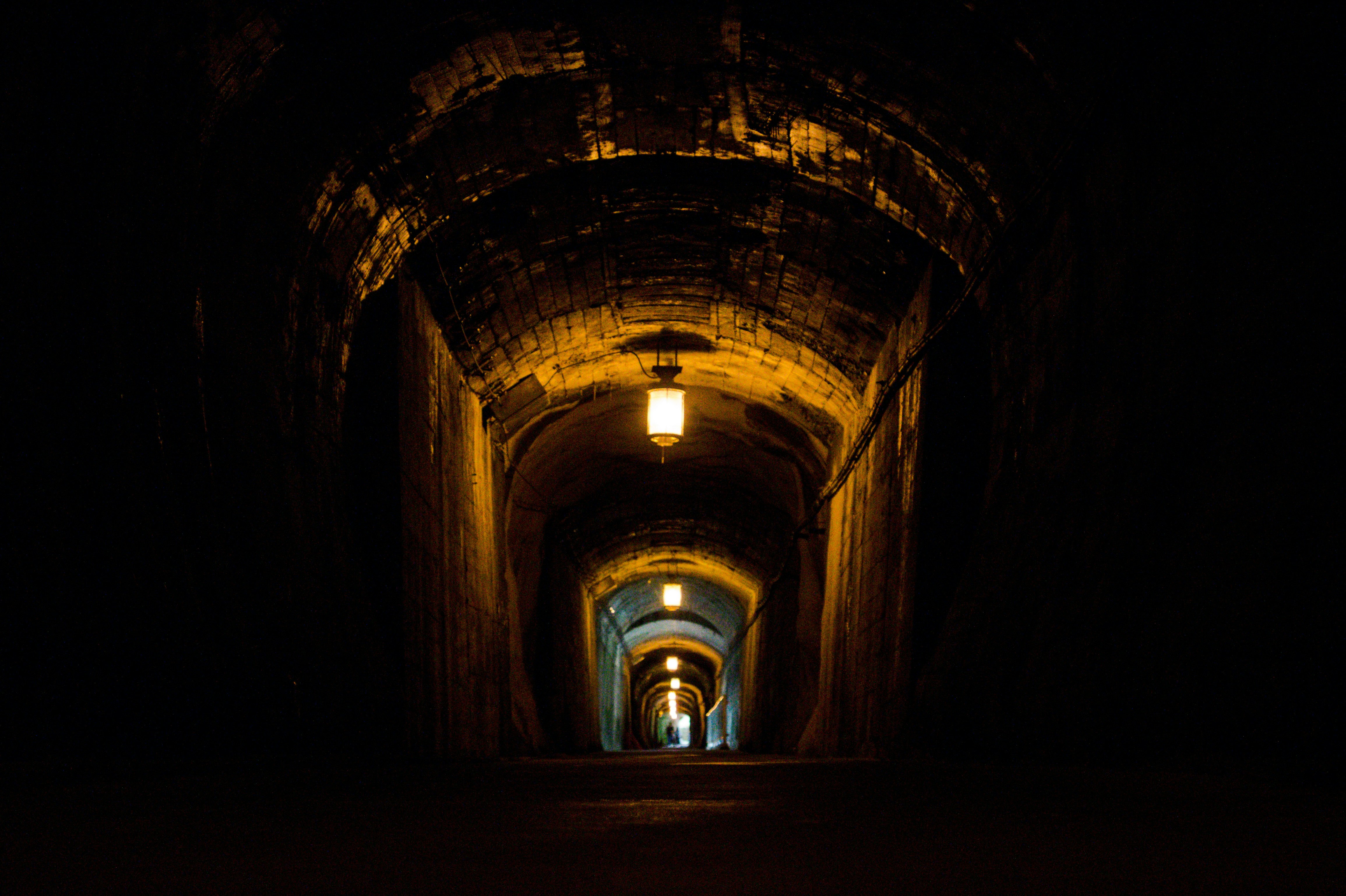 トンネルの奥へ続く照明のある暗い通路