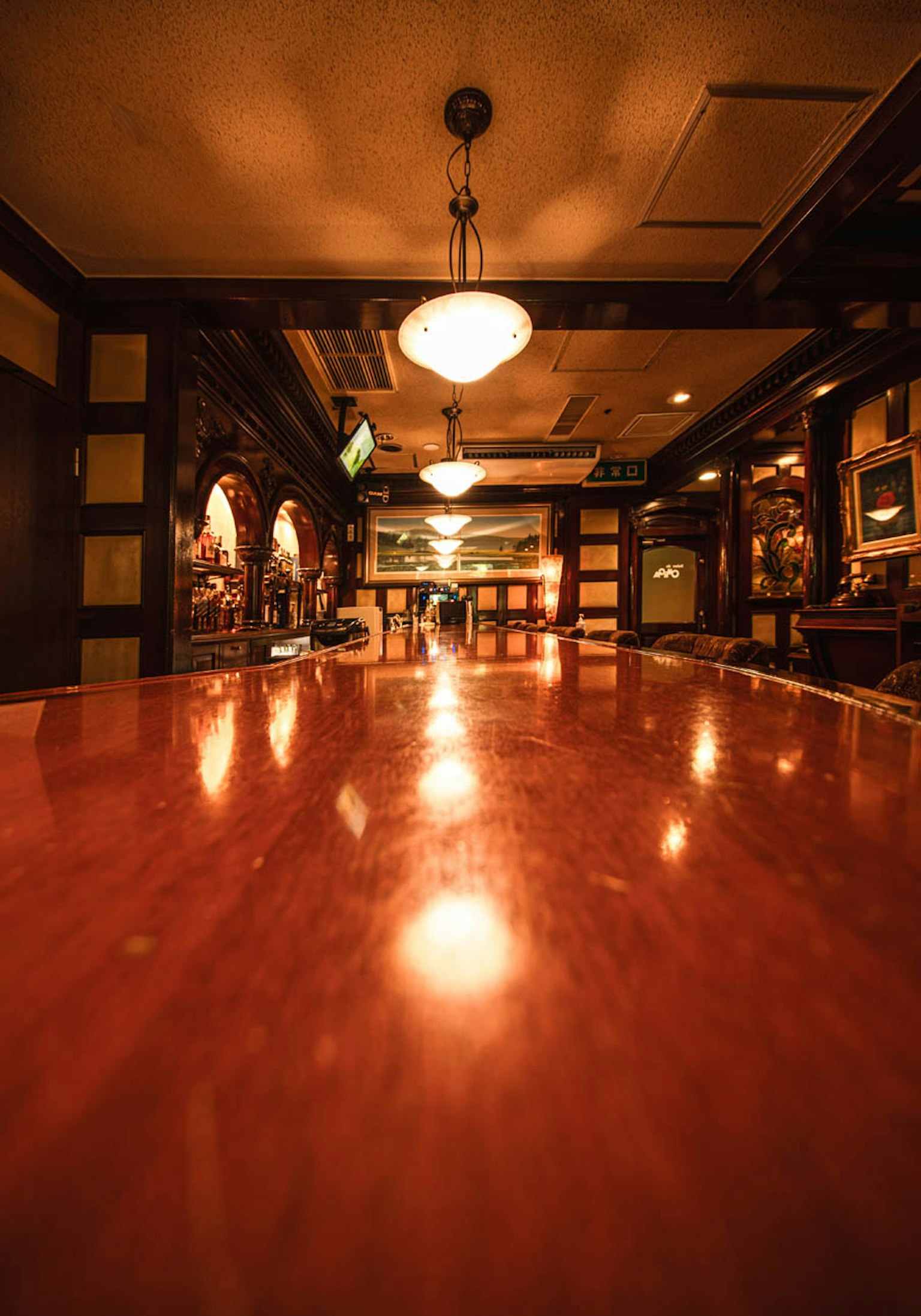 Intérieur d'un bar avec un comptoir en bois et un éclairage unique