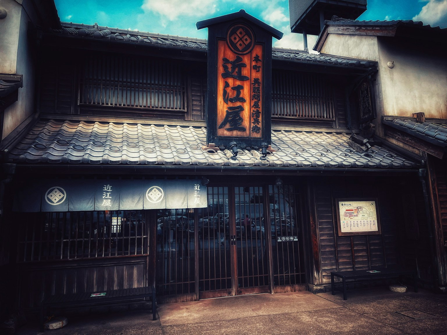 一座古老日本商店的外观，屋顶为瓦片，上面有写着江户屋的招牌