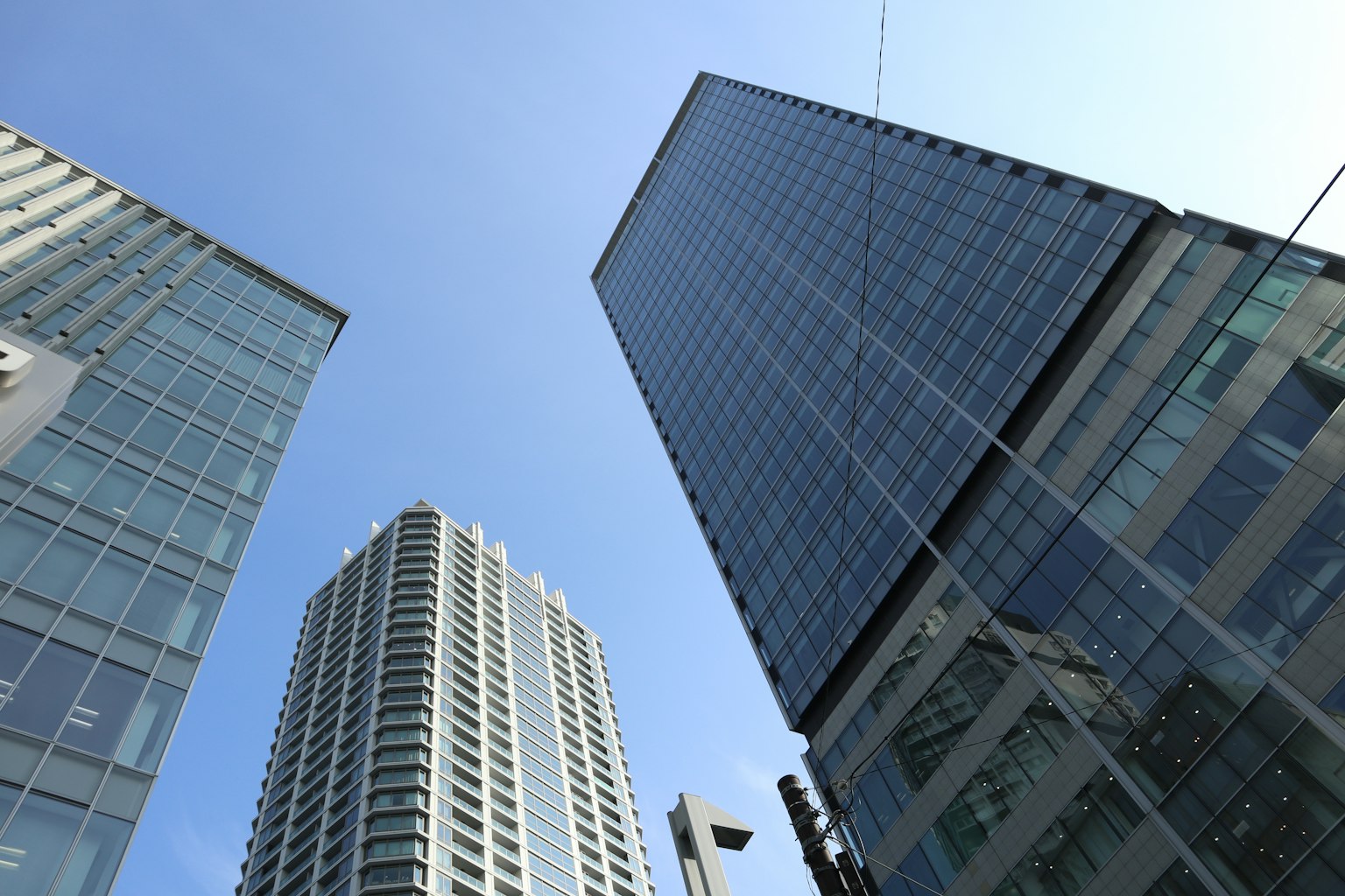Pemandangan gedung pencakar langit dari bawah dengan langit biru jernih