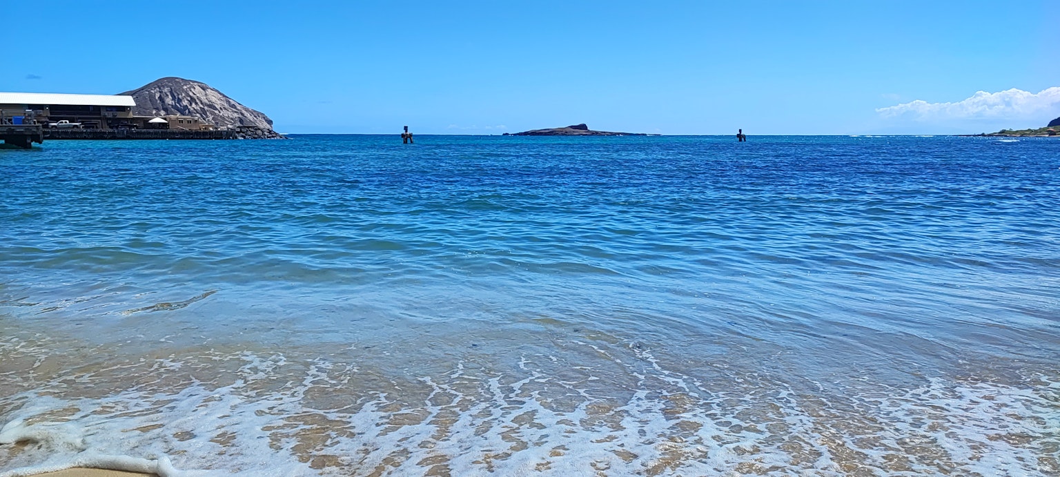 寧靜海灘的美麗景色，藍色海水和溫和的波浪