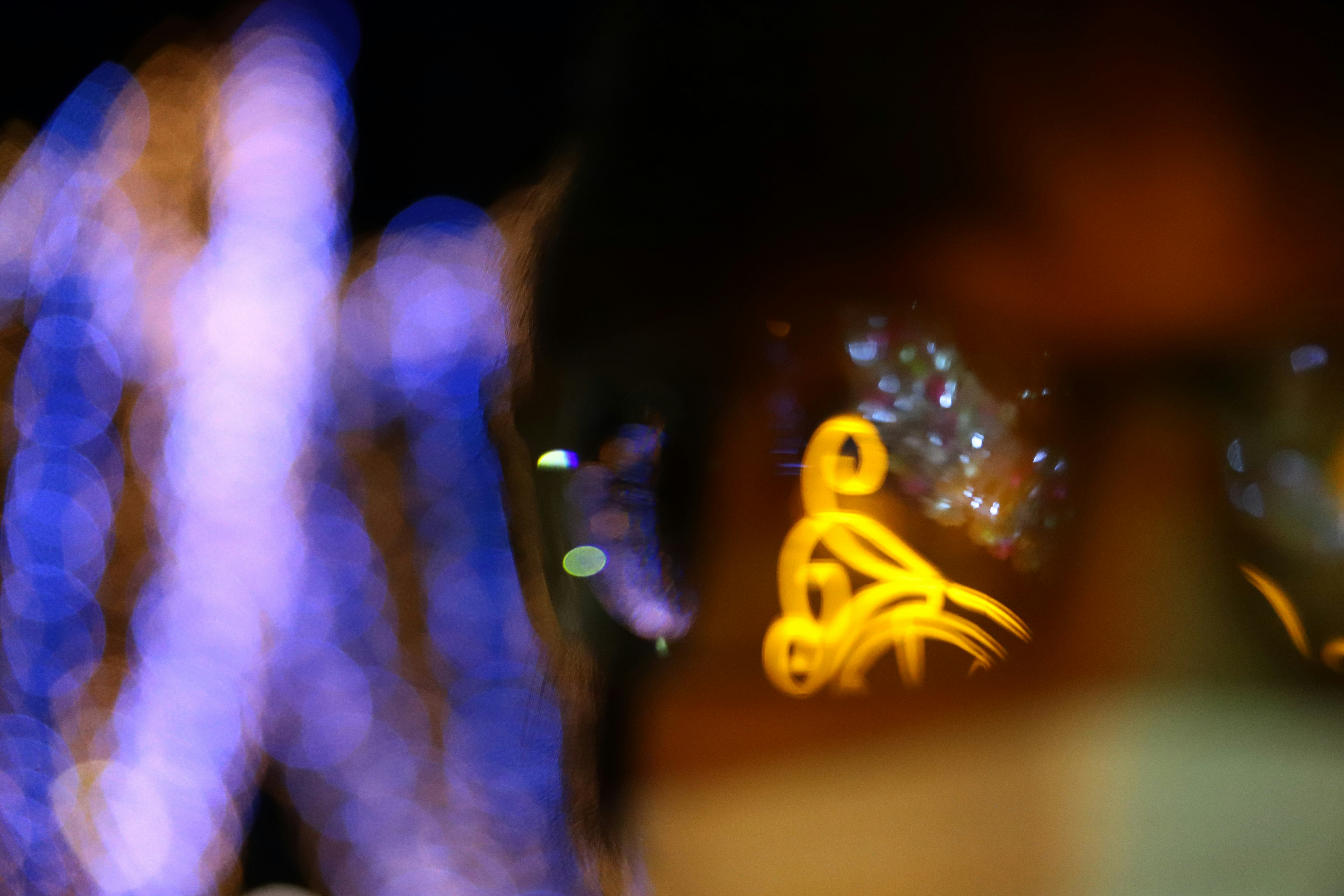 bokeh neon signs on a nighttime street corner with blurred figures