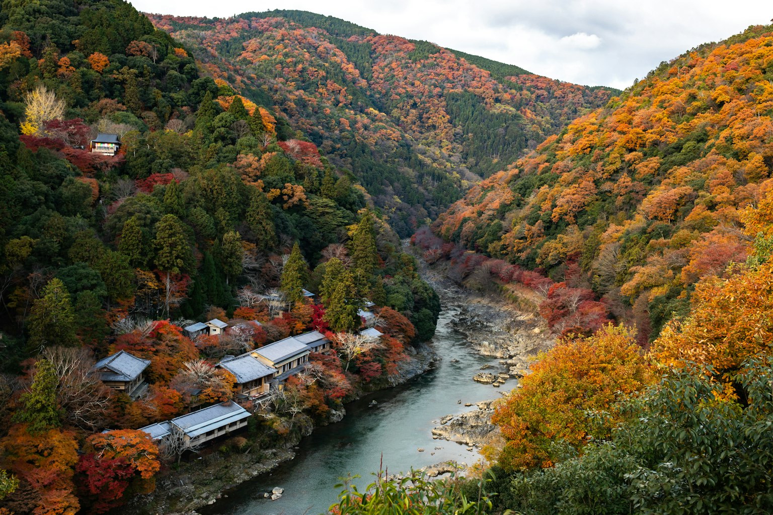 美しい秋の紅葉に囲まれた川と山の風景