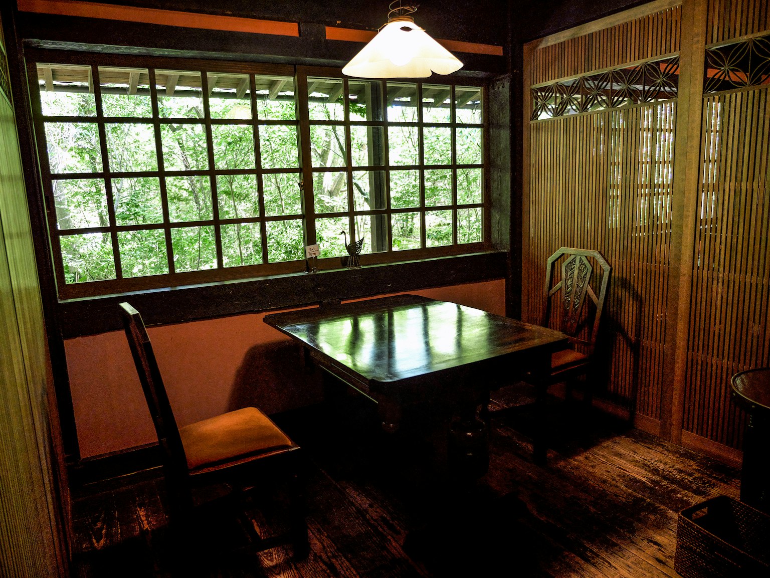 Japanisch gestalteter Raum mit Holztisch und Stühlen natürliches Licht, das durch das Fenster strömt