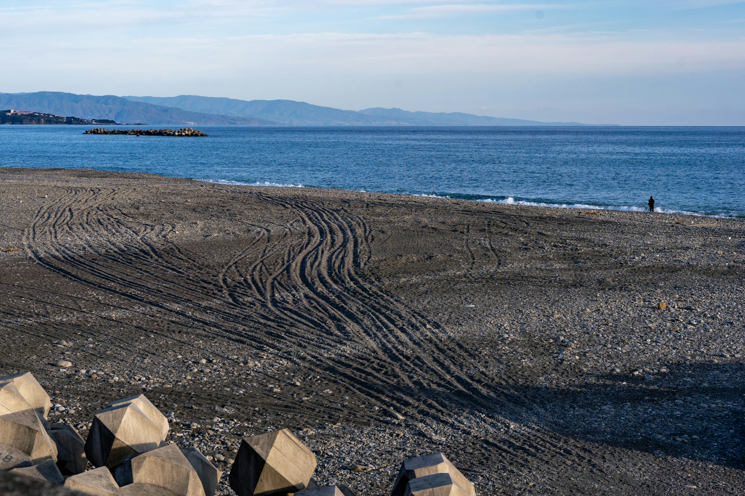 Coastal view with sandy beach and distant mountains