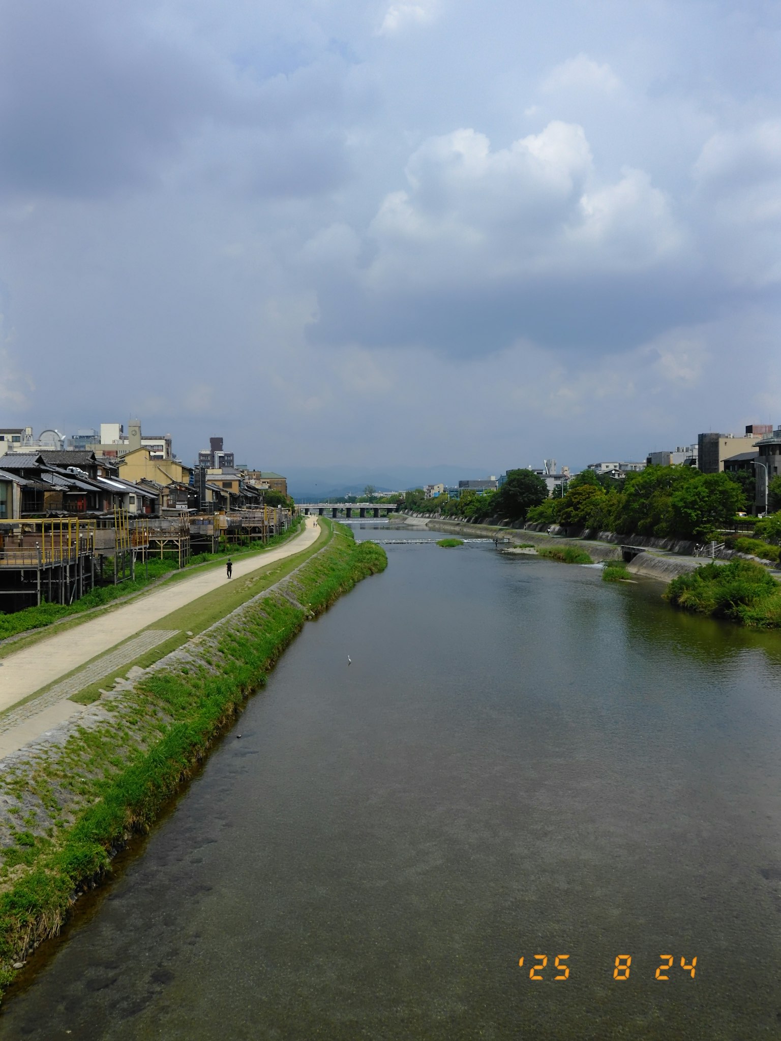 Vista escénica de un río con caminos verdes y edificios