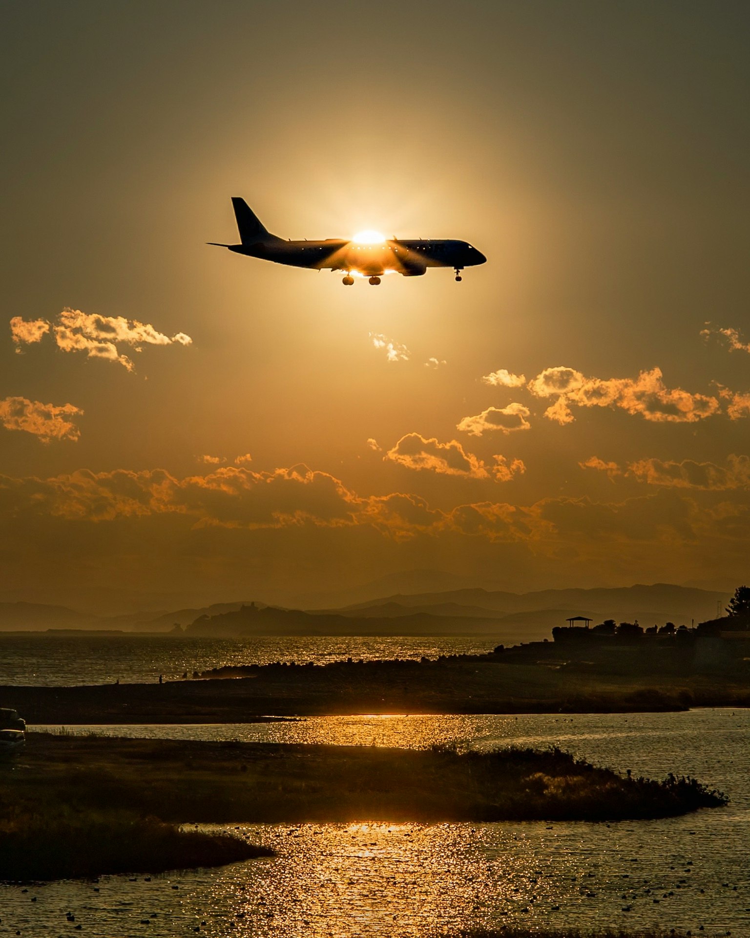 夕日を背景に飛行機が飛ぶ美しい風景