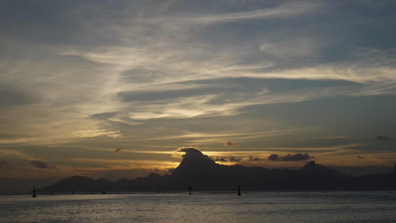 Vue panoramique d'une silhouette de montagnes et d'océan au coucher du soleil