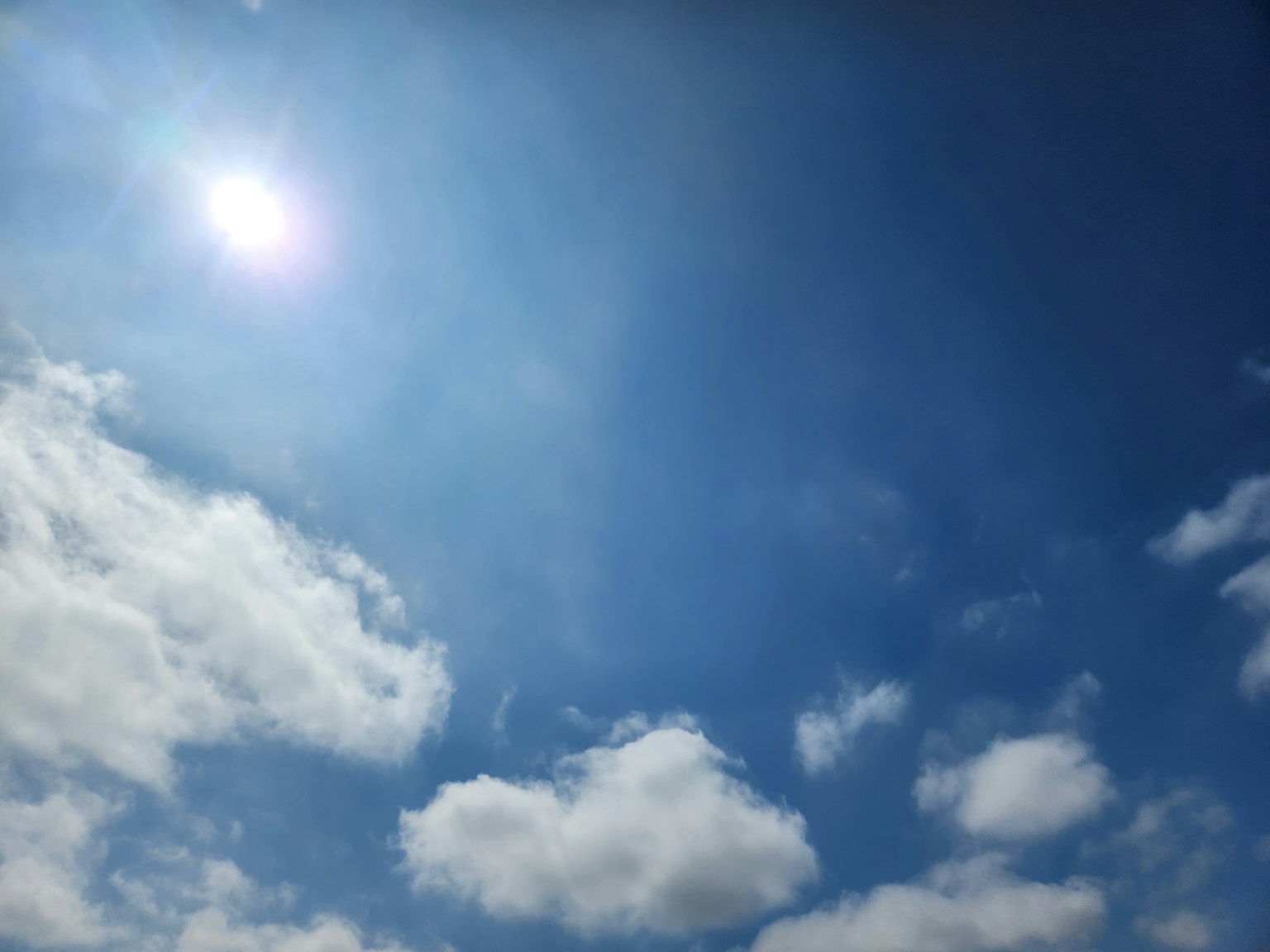 Heller blauer Himmel mit flauschigen weißen Wolken