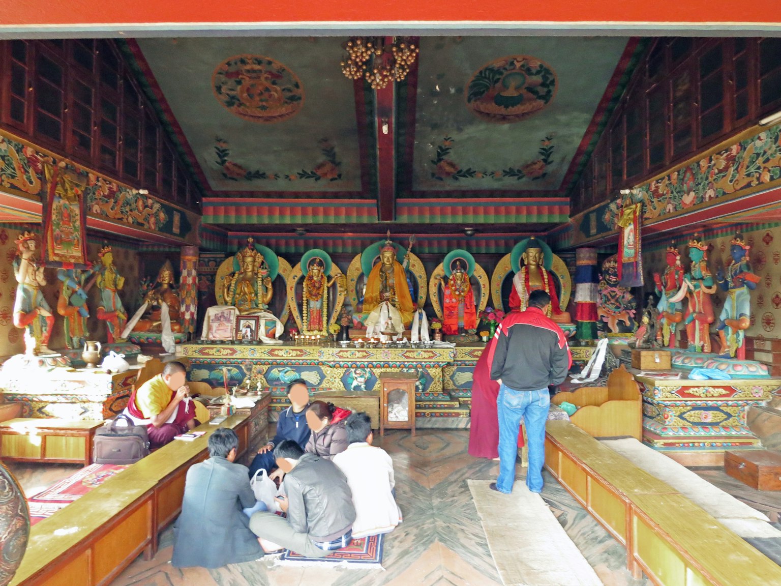 寺廟內部，有雕塑和佛像，信徒聚集