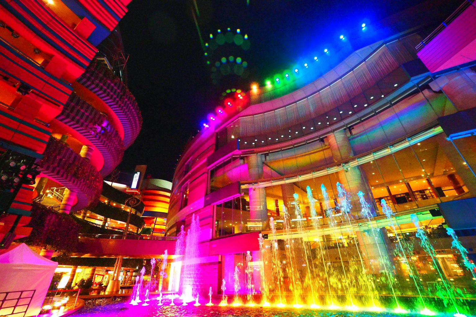 夜间色彩斑斓的城市景观，喷泉和灯光建筑