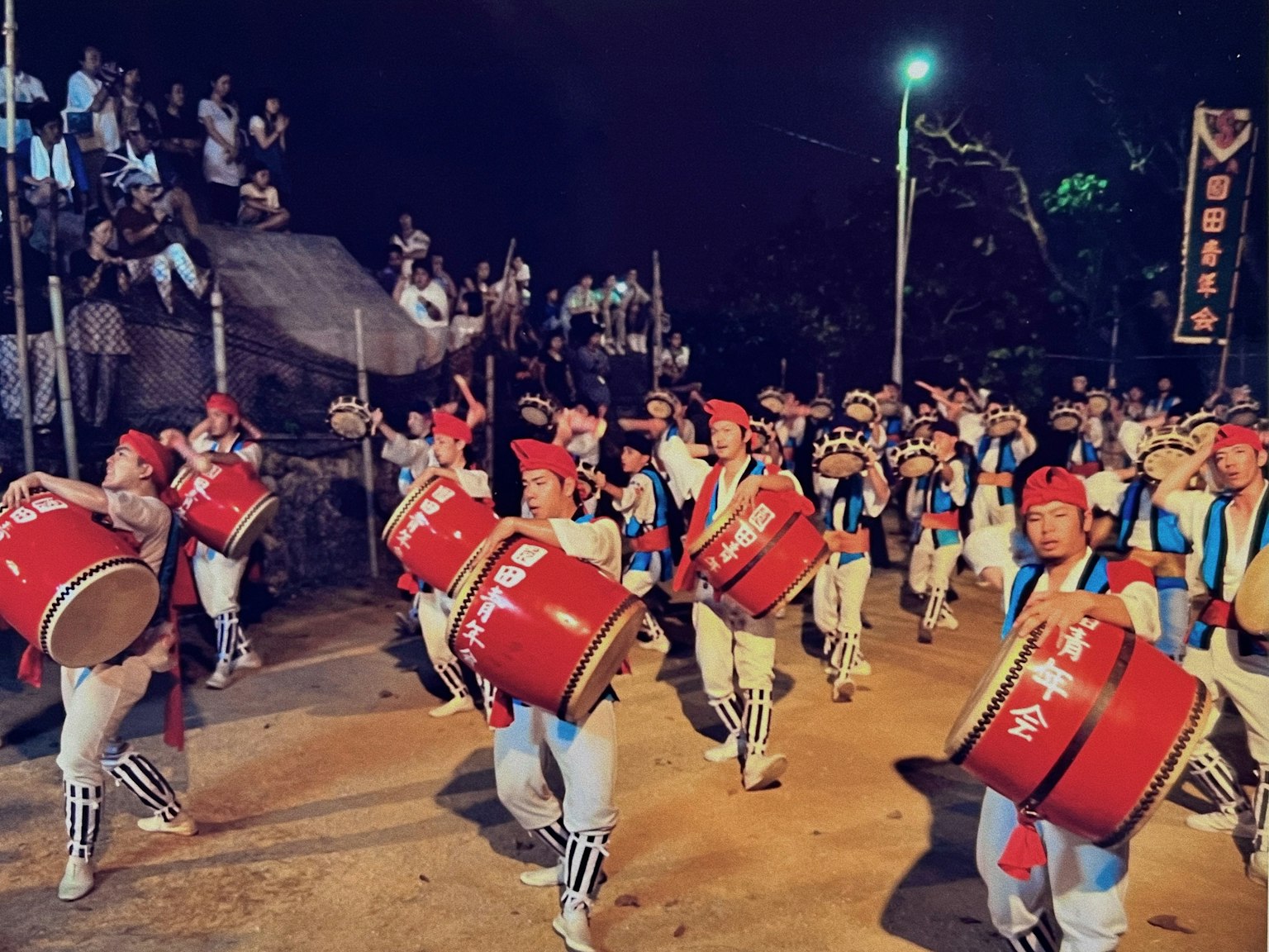 Grupo de personas bailando con tambores en un festival nocturno
