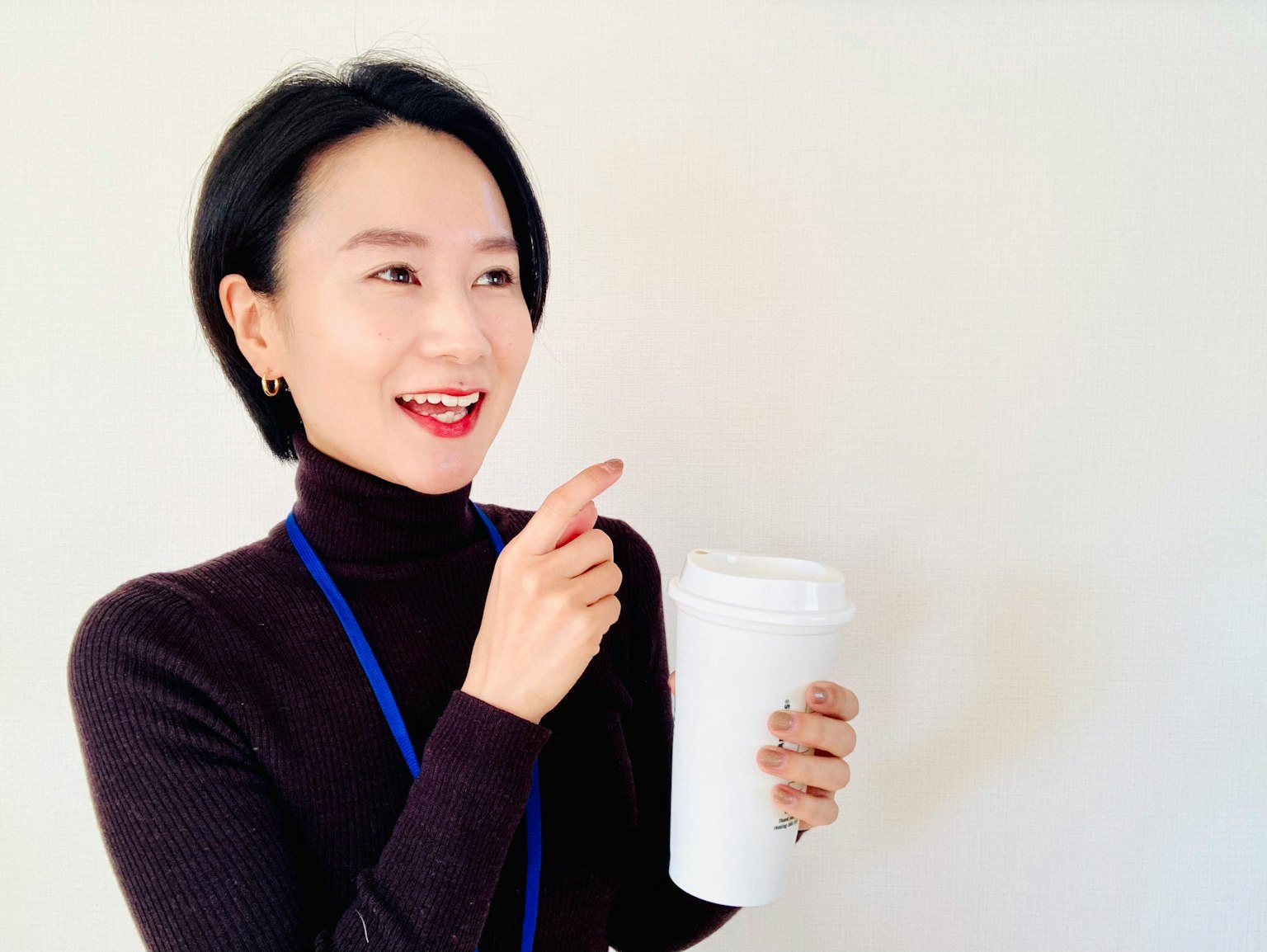 Woman smiling and holding a coffee cup