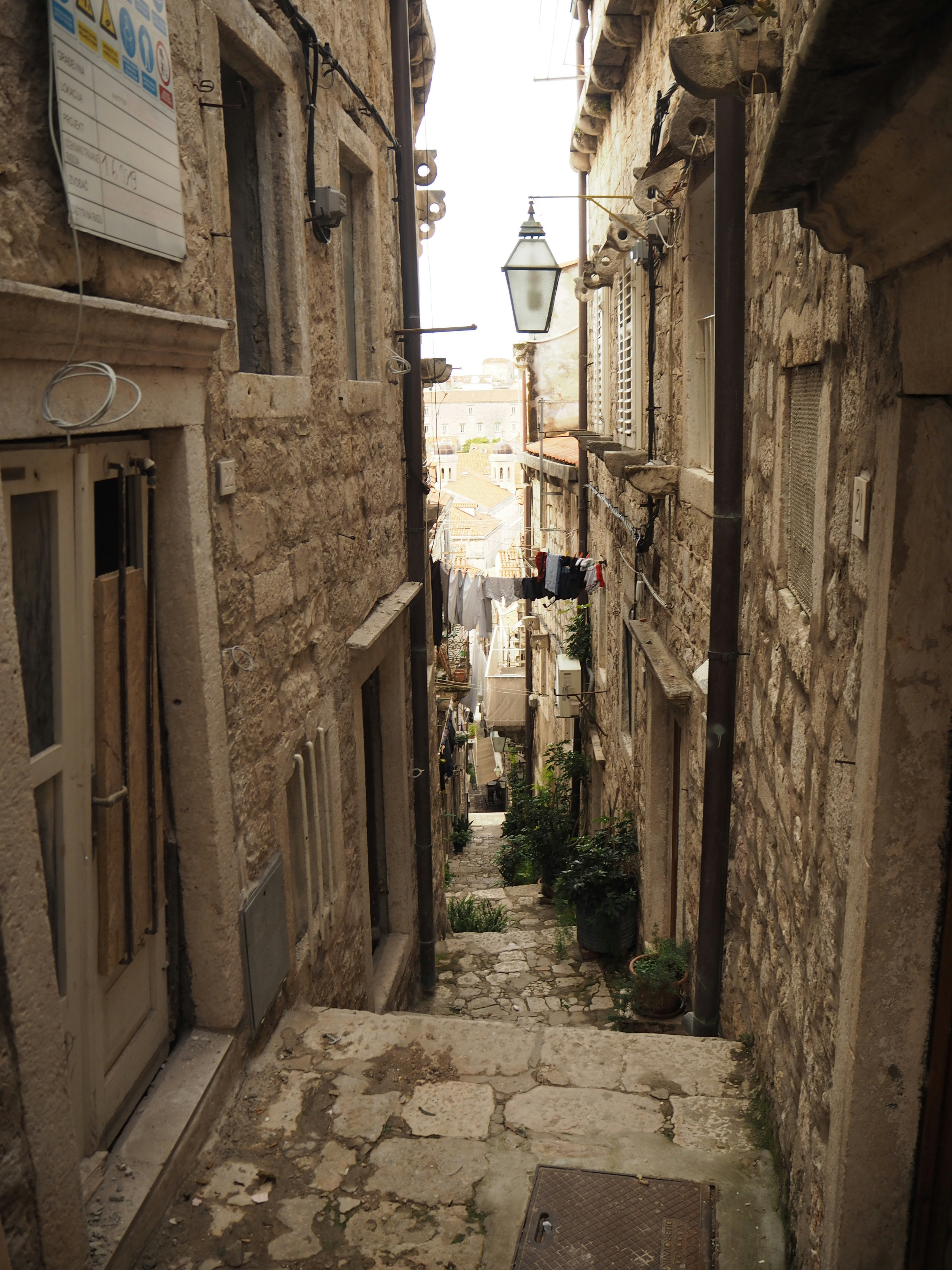stone buildings and a streetlamp along a narrow alley image