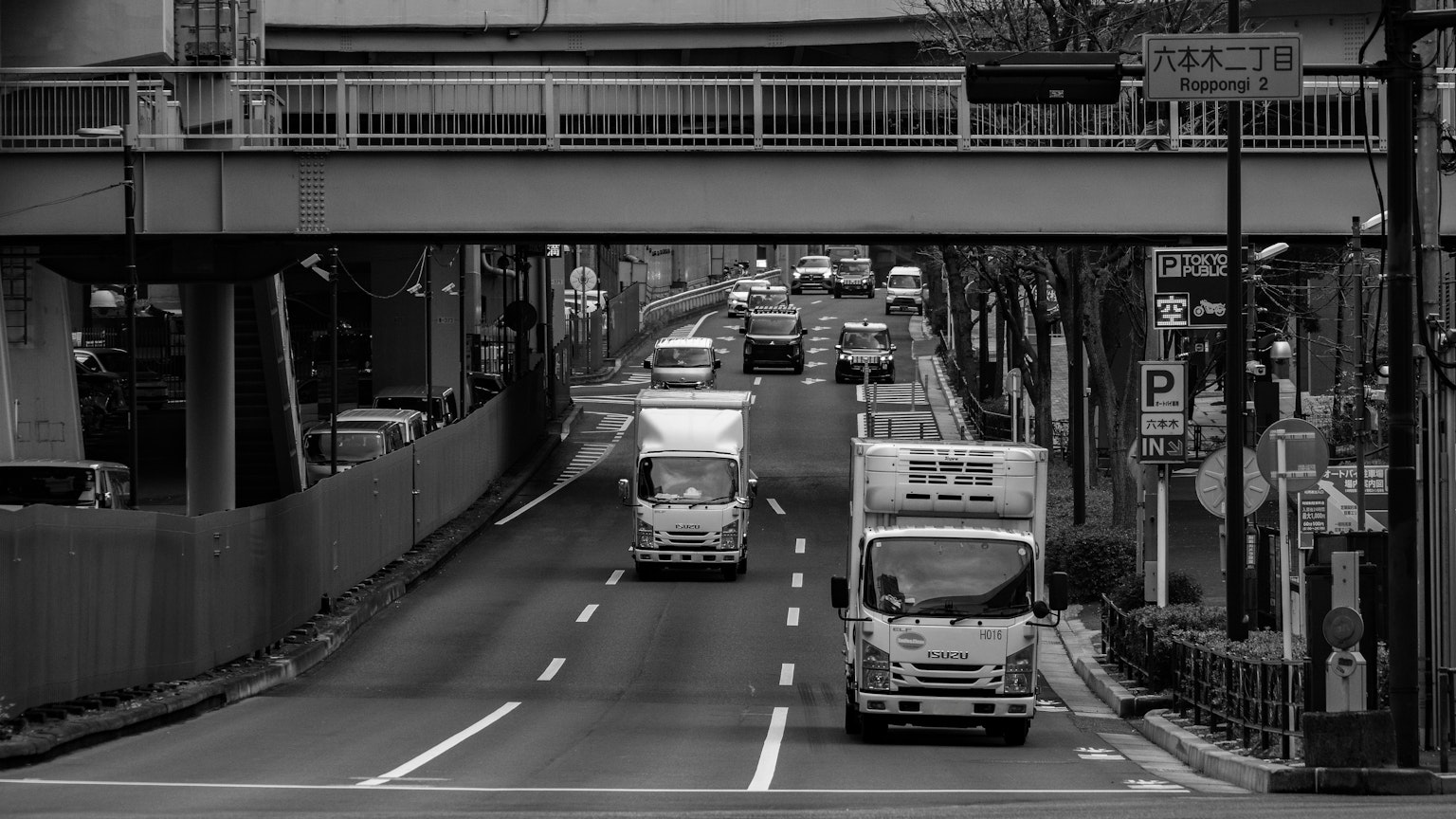 黑白城市風景，公路上有卡車和高架橋