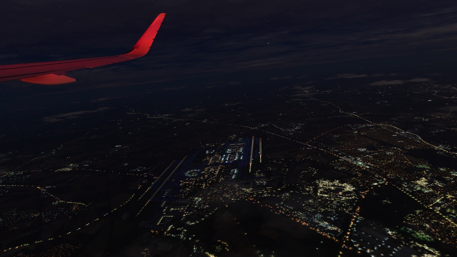 Stadtlichter aus der Luft bei Nacht mit Flugzeugflügel