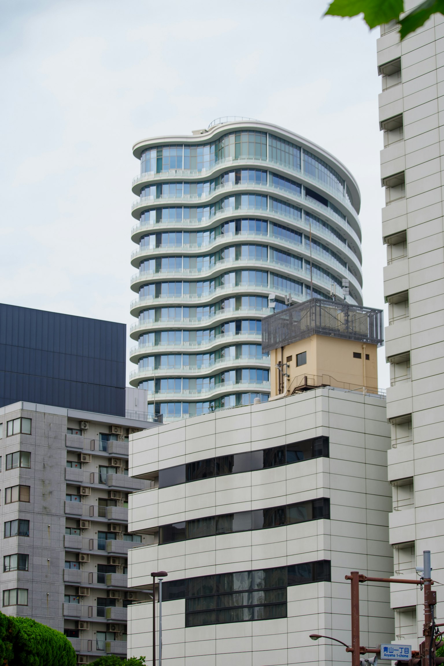 Ein modernes Gebäude mit geschwungenem Design, umgeben von anderen Strukturen