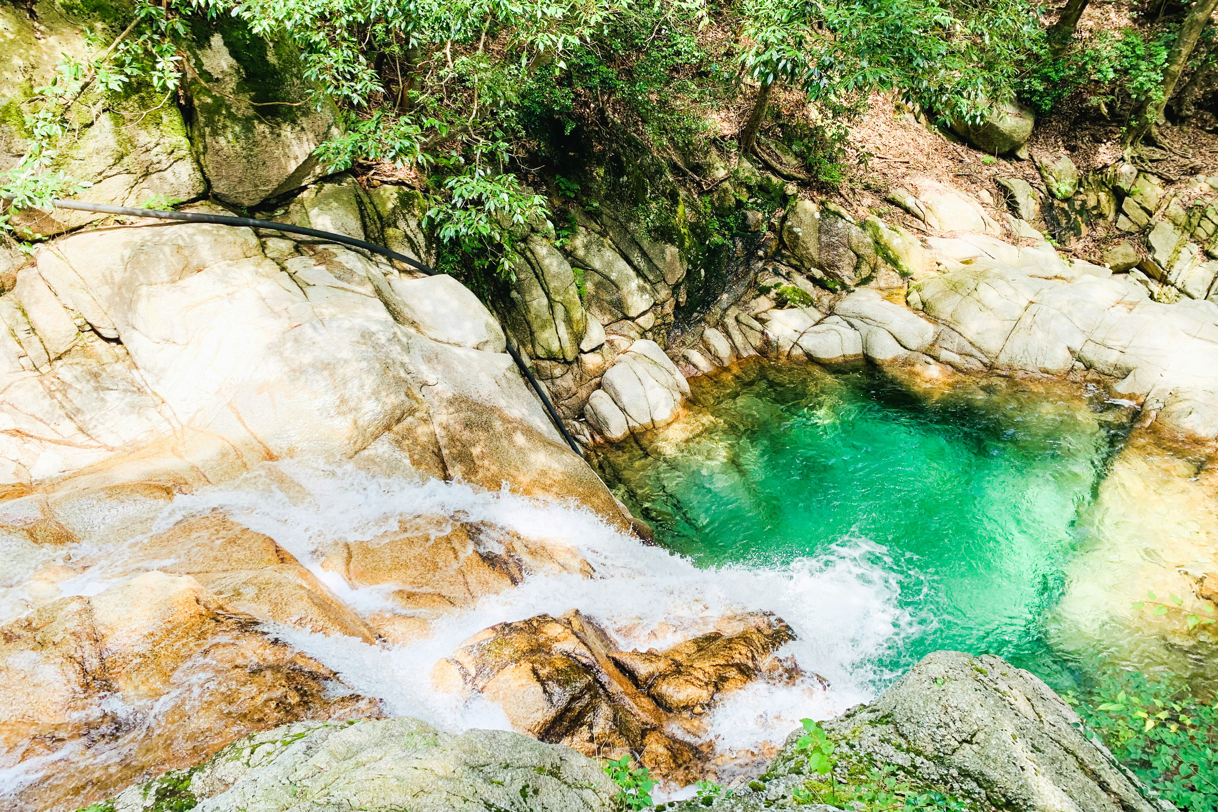 green-tinted river rapids and rocky gorge landscape