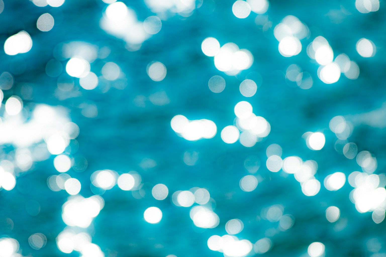 Immagine sfocata di luce scintillante su una superficie d'acqua blu