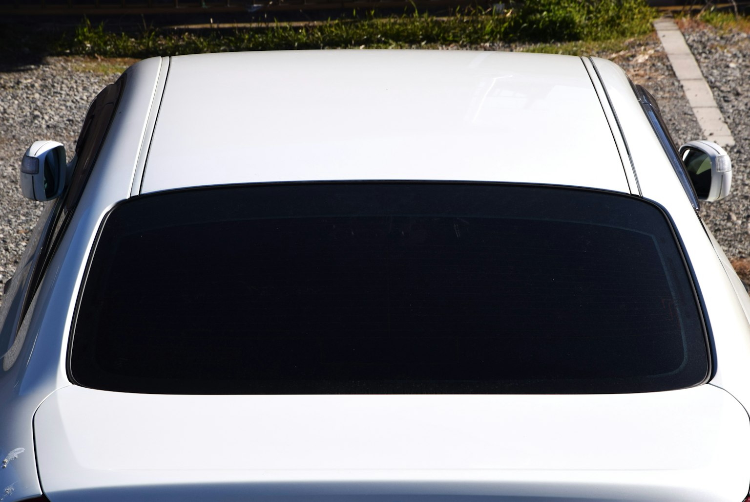 Image of the top view of a white car with tinted windows