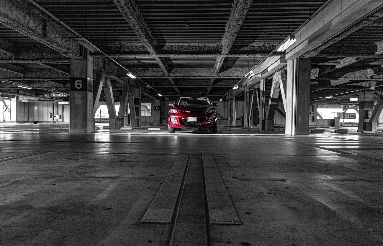 주차장에서 빨간 차가 있는 흑백 이미지