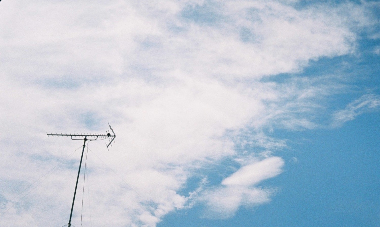 Una foto di un cielo blu con nuvole bianche e un'antenna