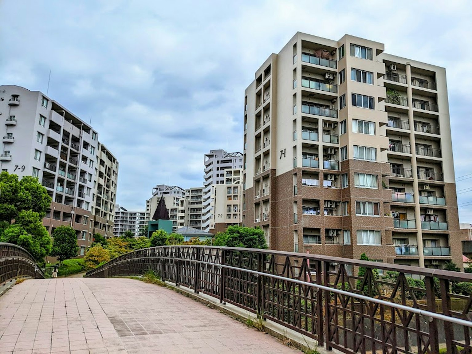 Modern buildings lining a street with a bridge