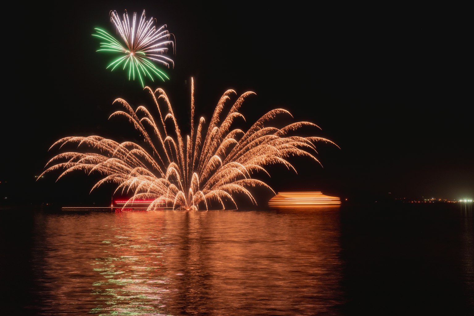 Colorful fireworks display over water at night