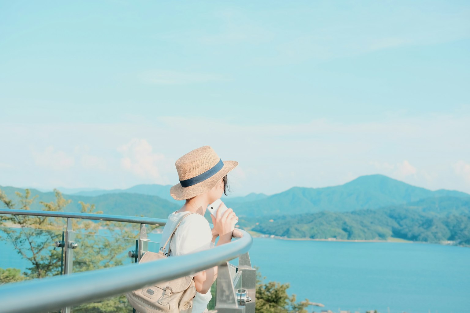 戴着帽子的女人俯瞰海洋和山脉的美景