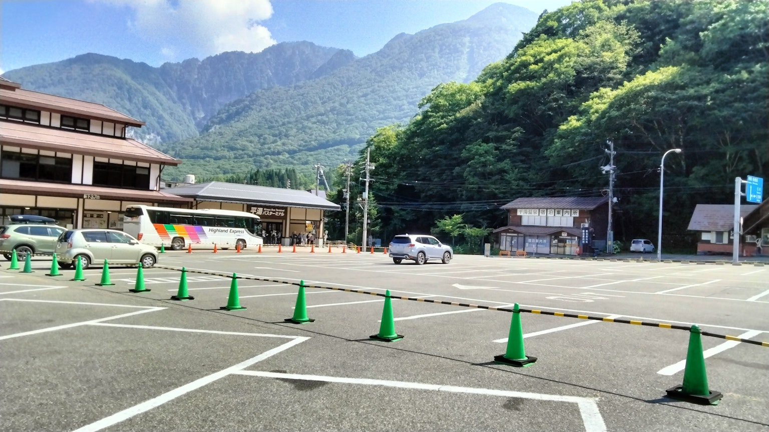 Grand parking entouré de montagnes cônes verts alignés