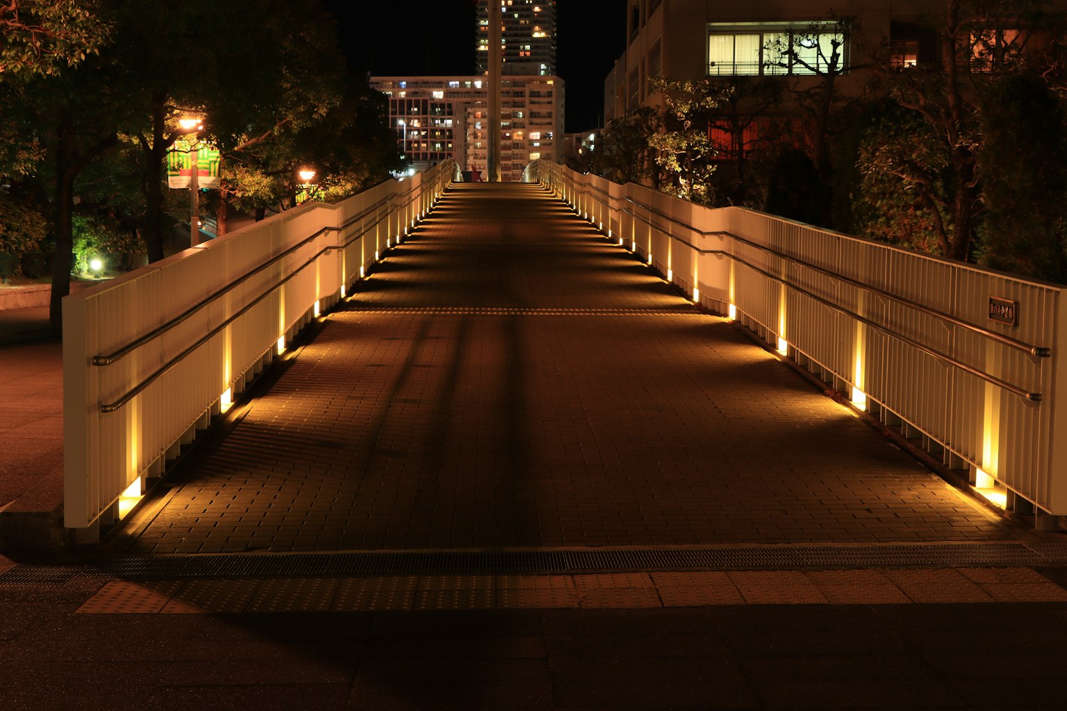 สะพานคนเดินที่มีแสงสว่างในเวลากลางคืน