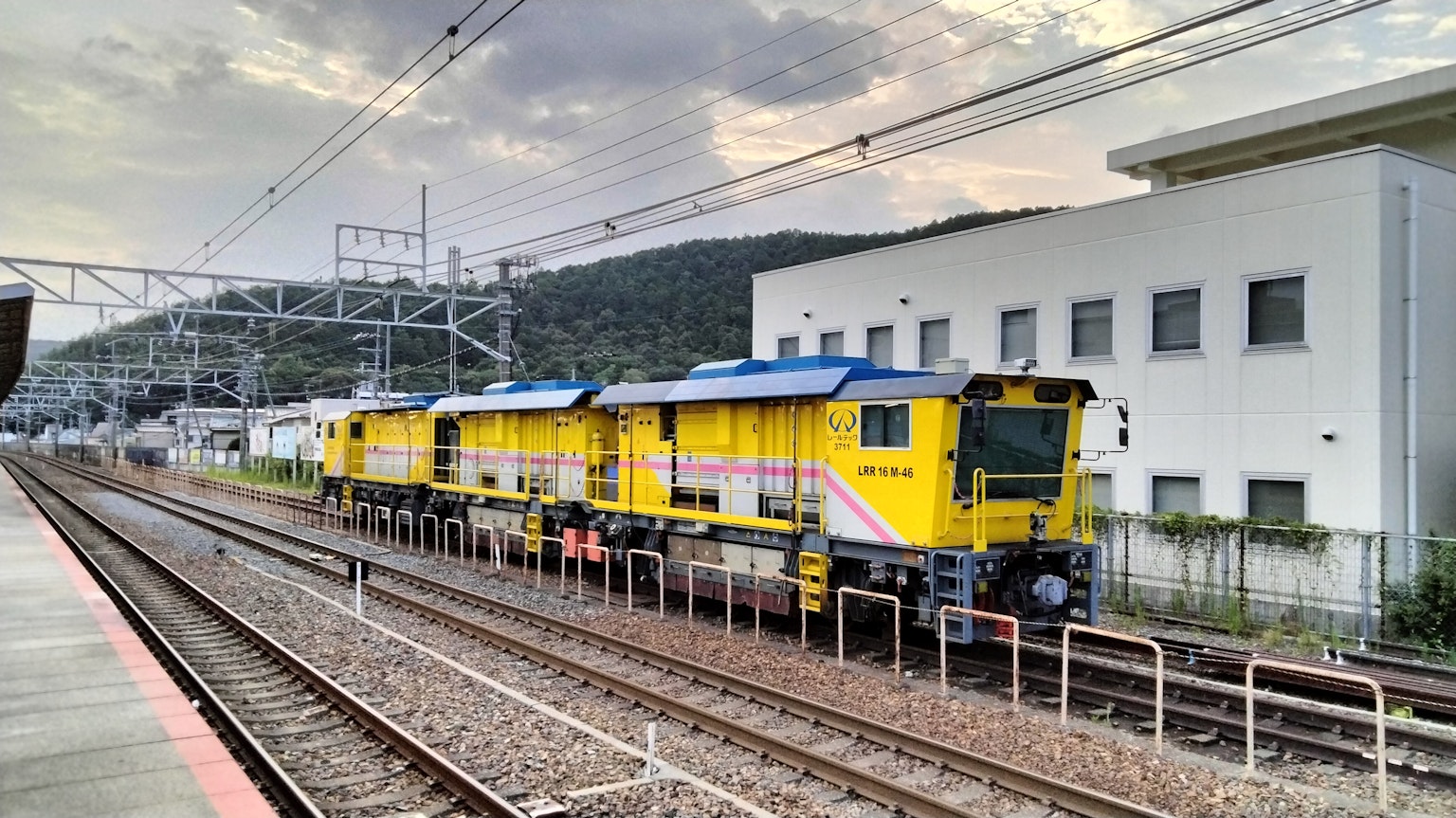 Locomotives jaunes garées sur la voie ferrée avec un bâtiment en arrière-plan