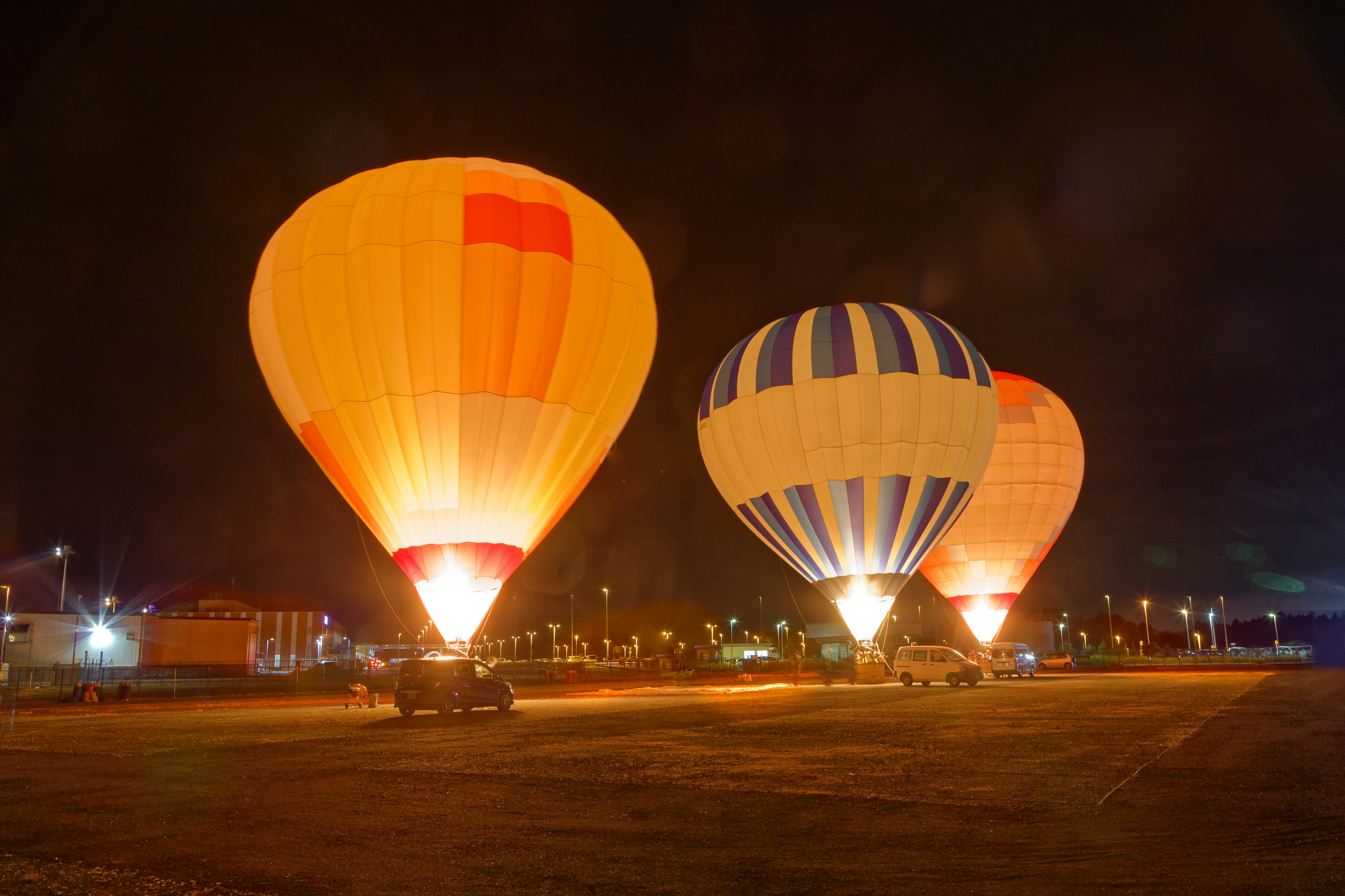 Escena nocturna en el aeropuerto de Ibaraki con globos aerostáticos iluminados en el cielo