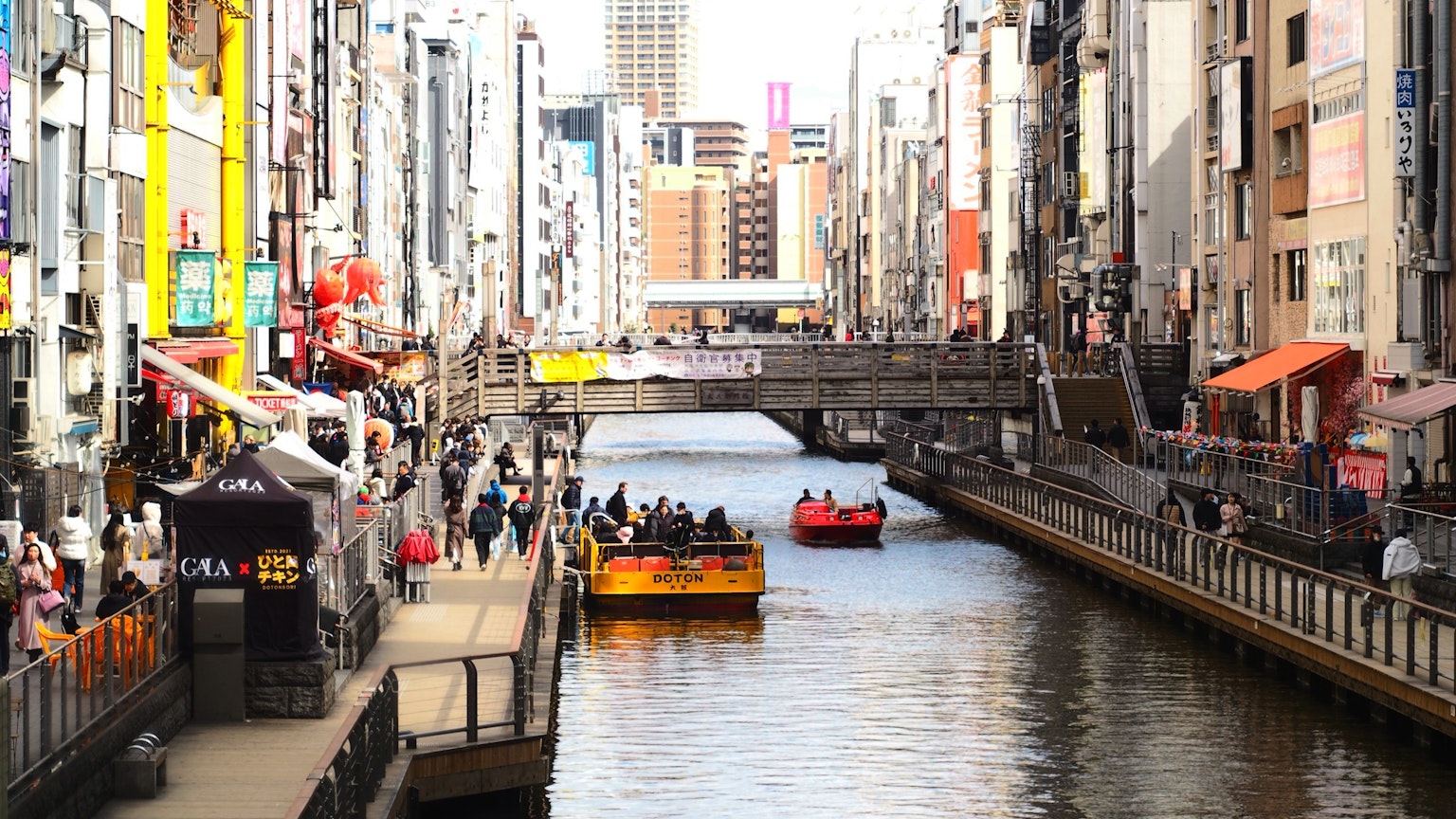 Belebter Kanal mit Stadtansicht und Booten