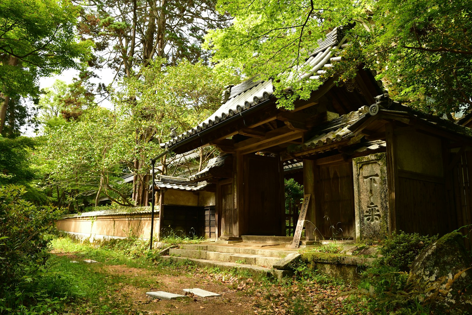 Edificio histórico con una antigua puerta japonesa rodeada de vegetación