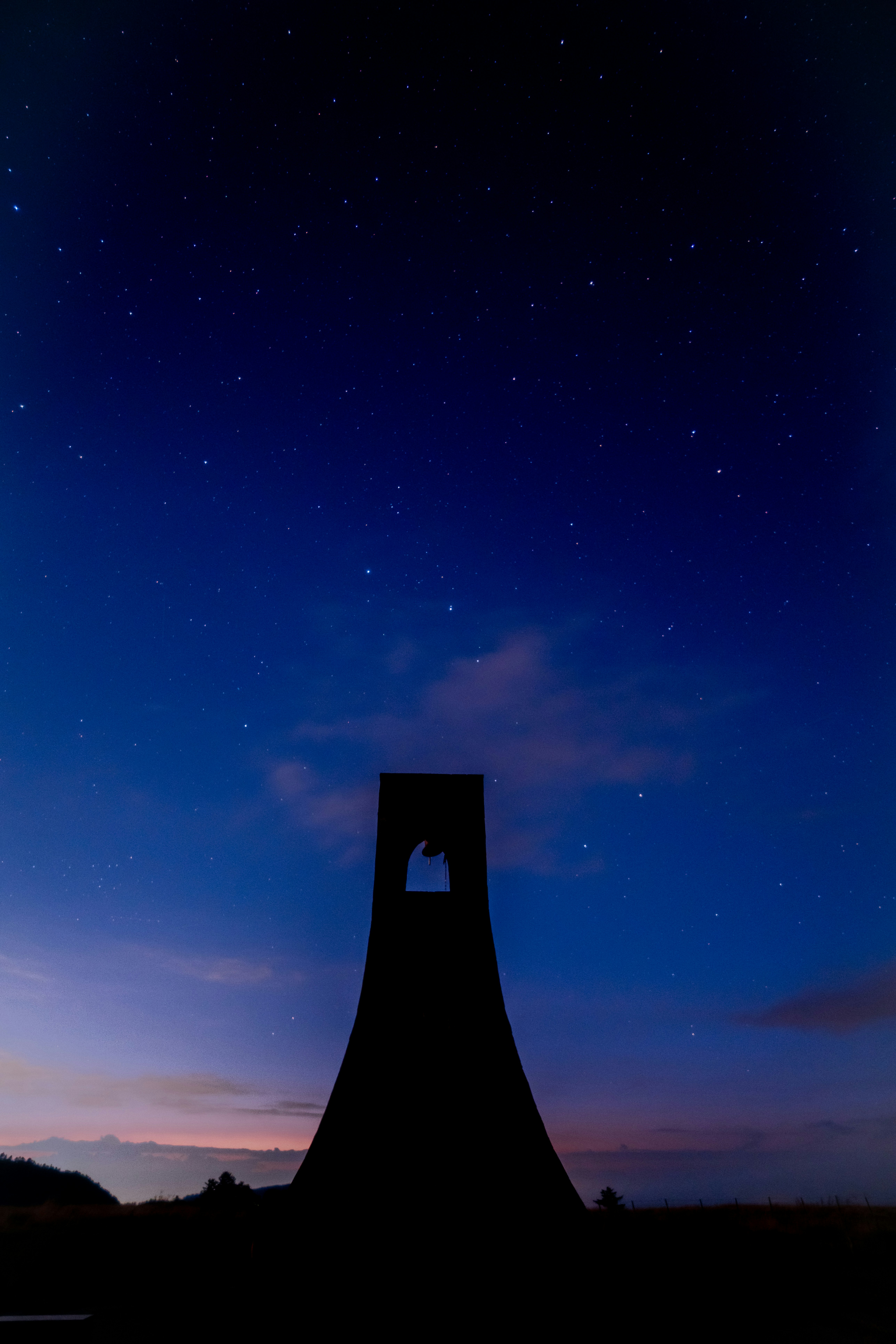silhouette de phare sur un ciel nocturne étoilé