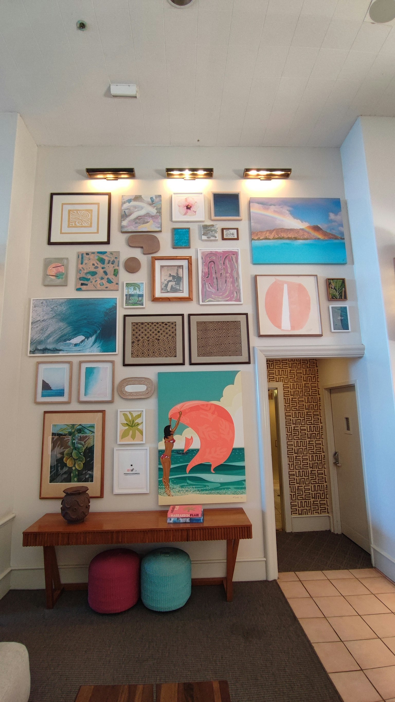 Bunte Kunstwerke an einer Wand mit einem Holztisch und Kissen
